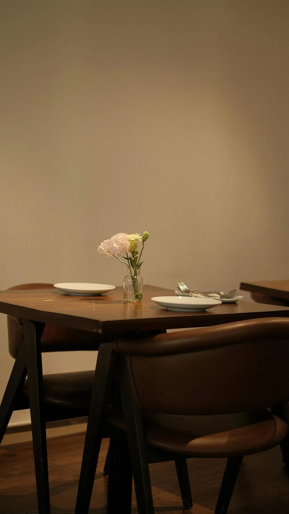 Warm dining table with soft flowers, wood tones, and gentle evening light
