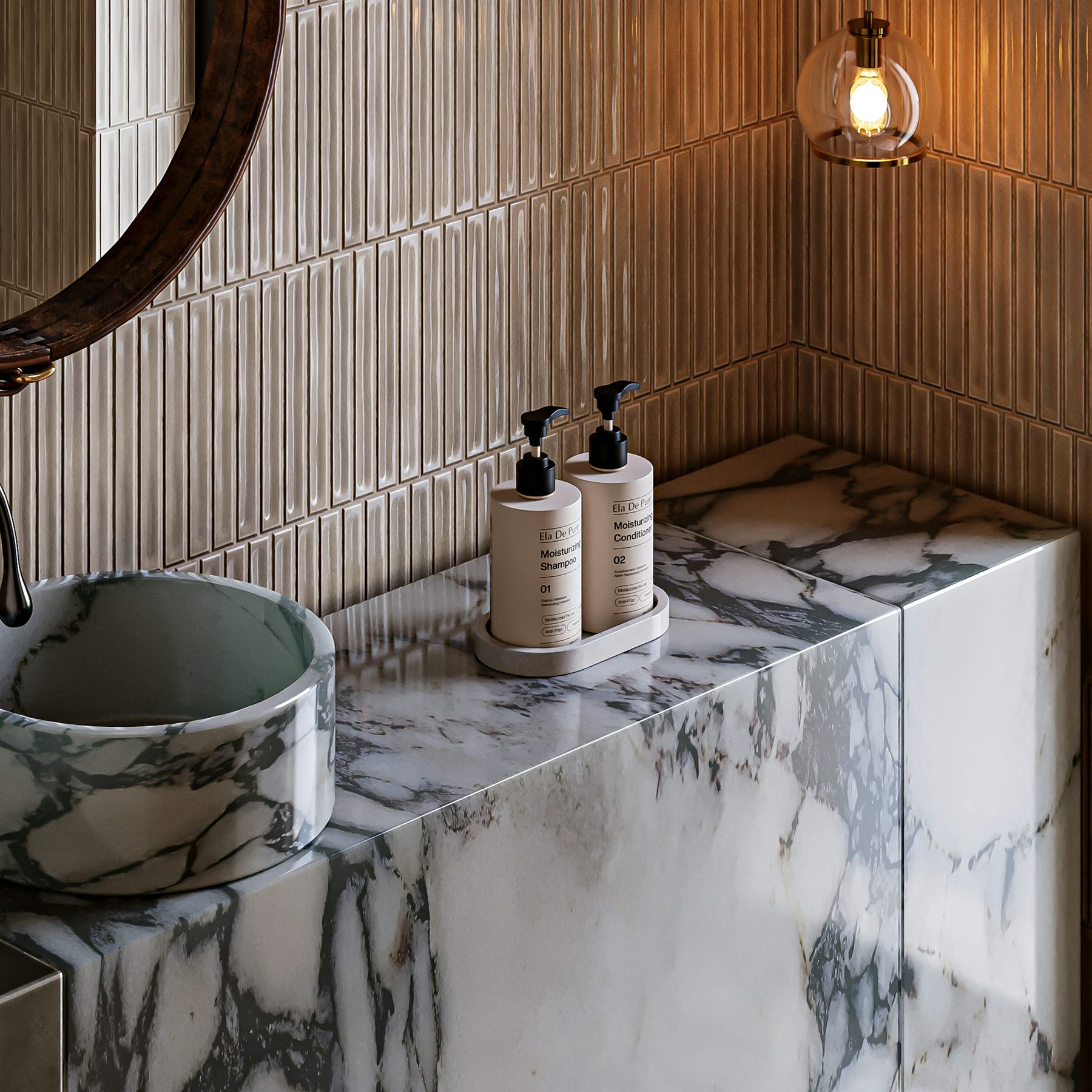 Marble bathroom counter with warm beige wall tile, a round sink, and softer brass lighting