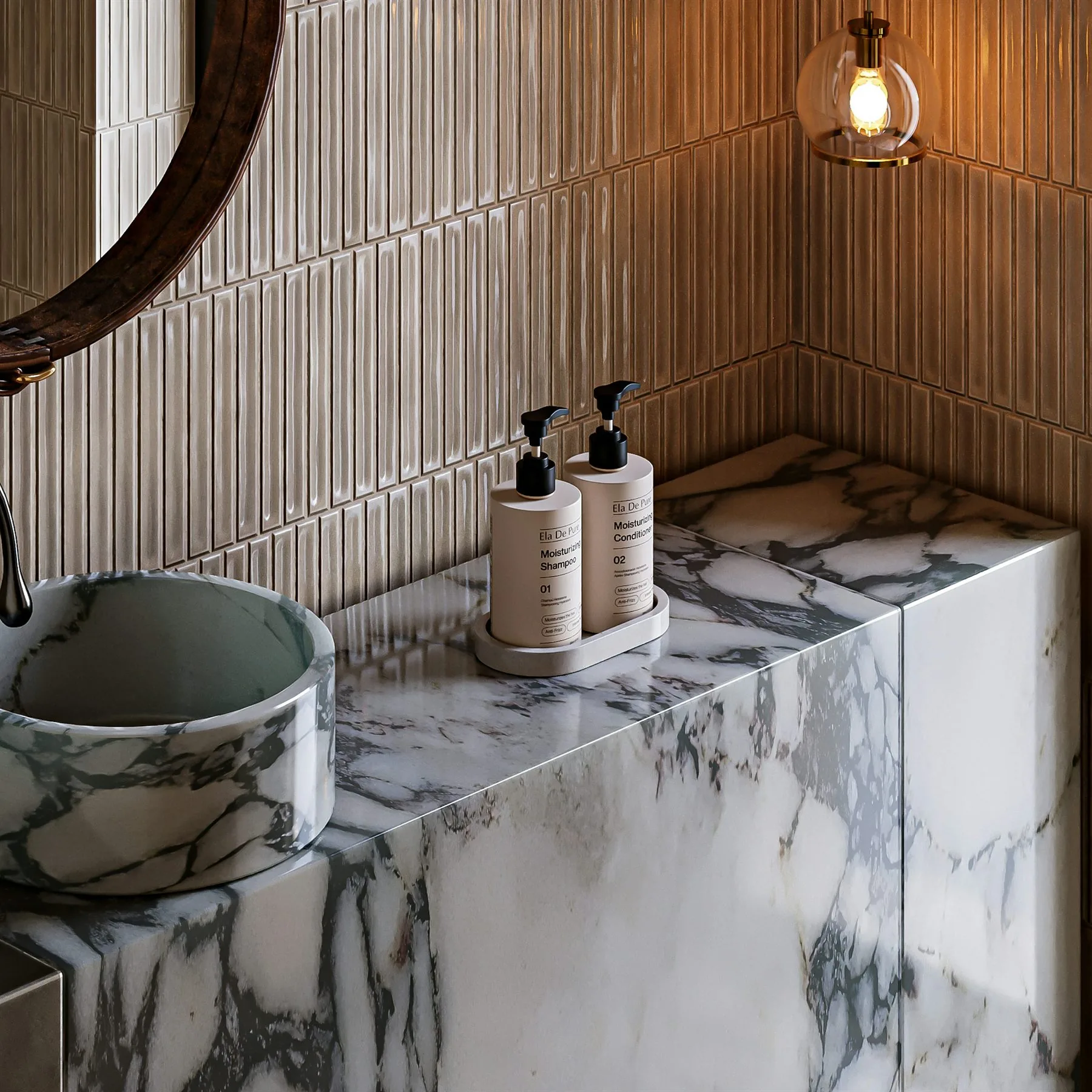 Marble bathroom counter with warm beige wall tile, a round sink, and softer brass lighting