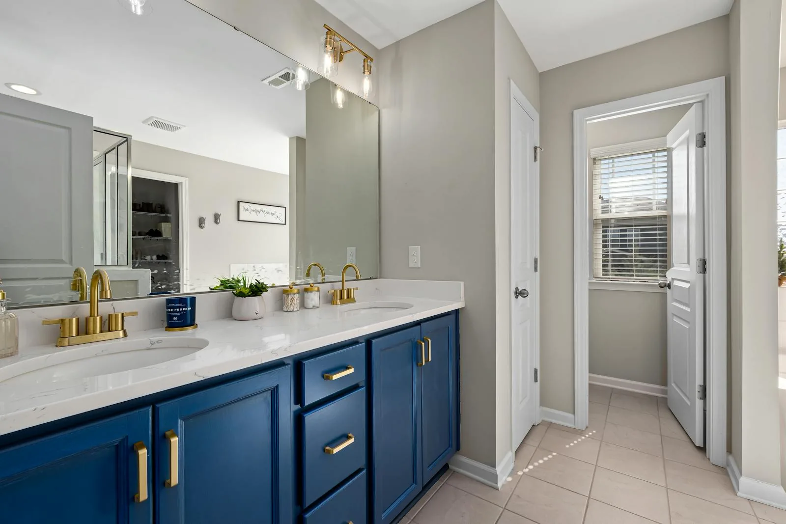 Bathroom with blue vanity, warm brass fixtures, and clean white walls