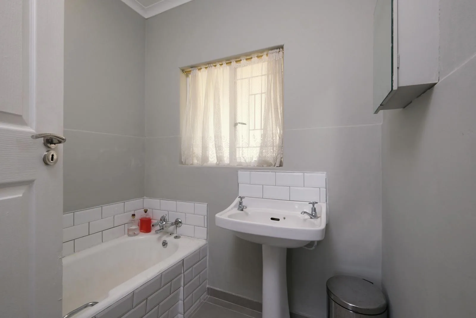 Small bathroom with cool gray walls, white tile, and limited warmth