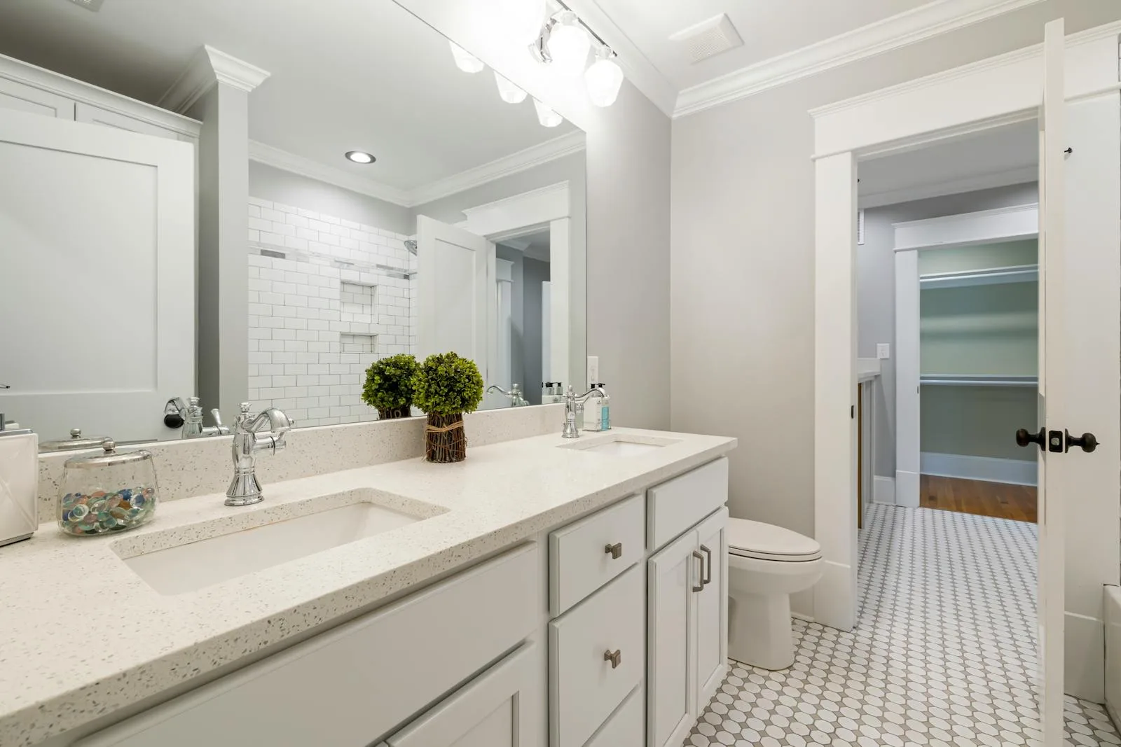 Bright bathroom vanity with plants, mirrors, and soft neutral styling