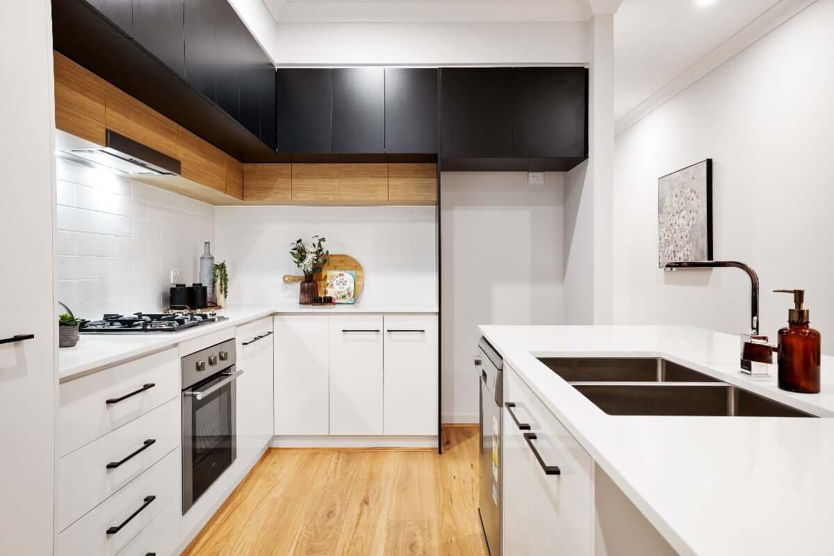 Bright organized kitchen with clear counters, white surfaces, and warmer wood accents