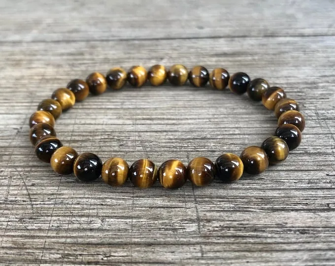 Simple tiger eye bead bracelet on a wood surface showing a more minimal bracelet idea