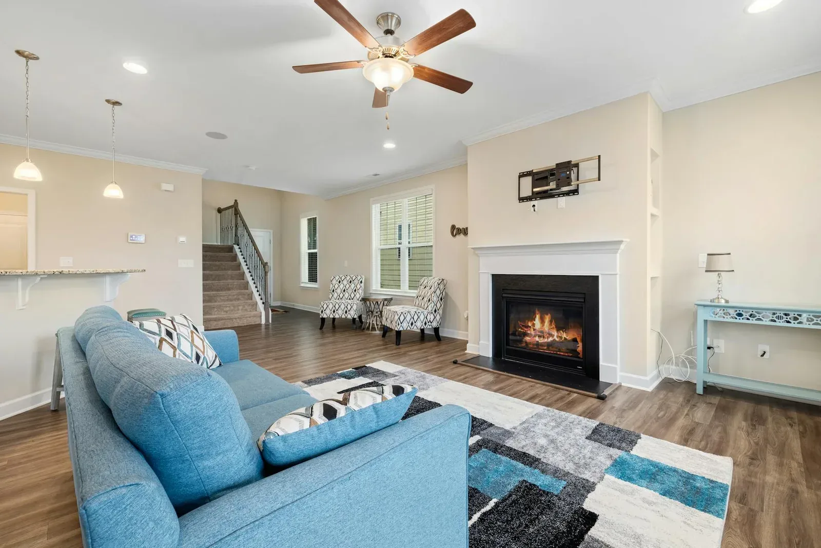 Living room with blue sofa, warm fireplace, cream walls, and a cool but balanced palette