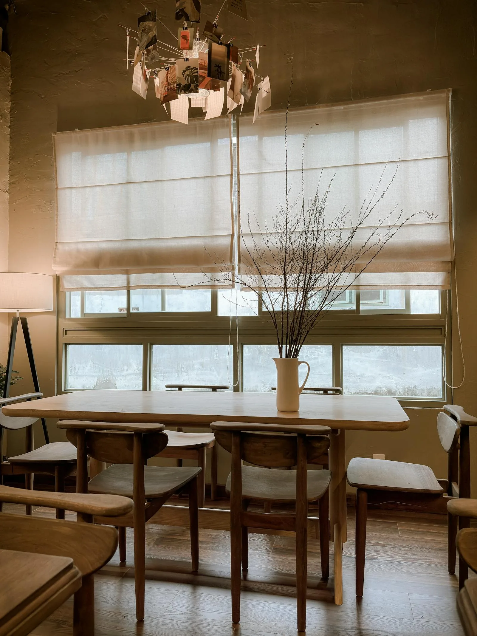Warm dining area with a clear table, simple chairs, and filtered daylight