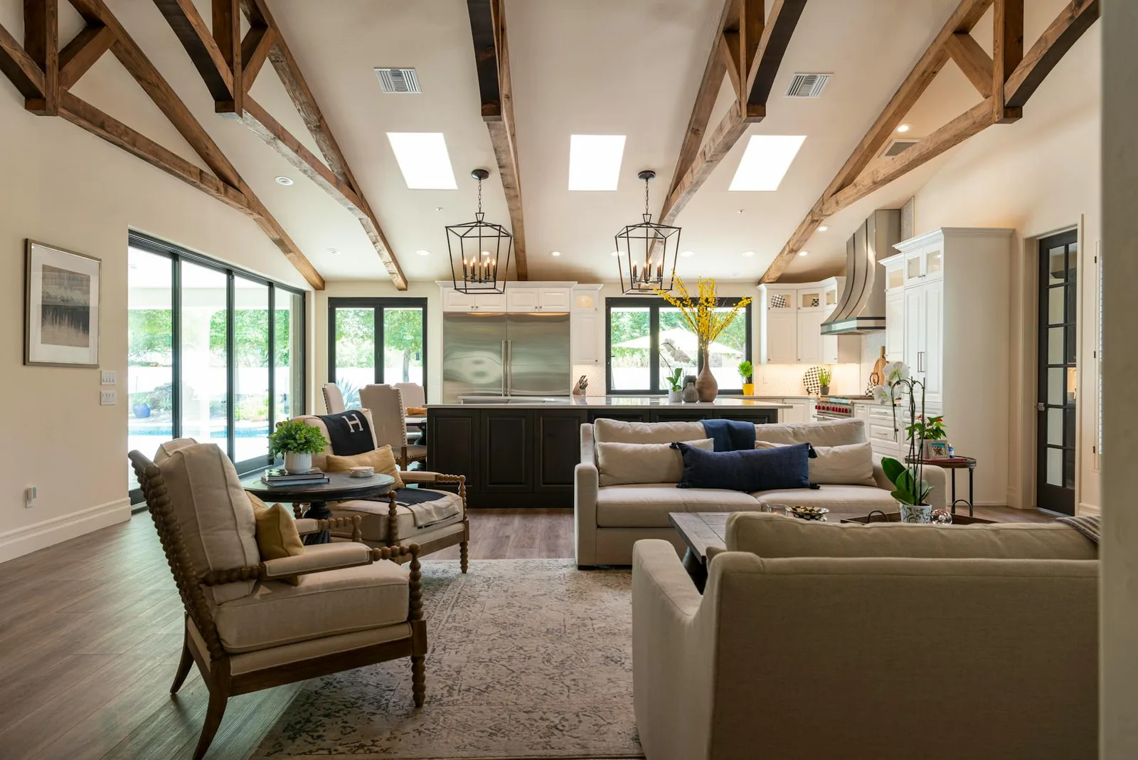 Warm beige living room with wood beams, soft seating, and natural light