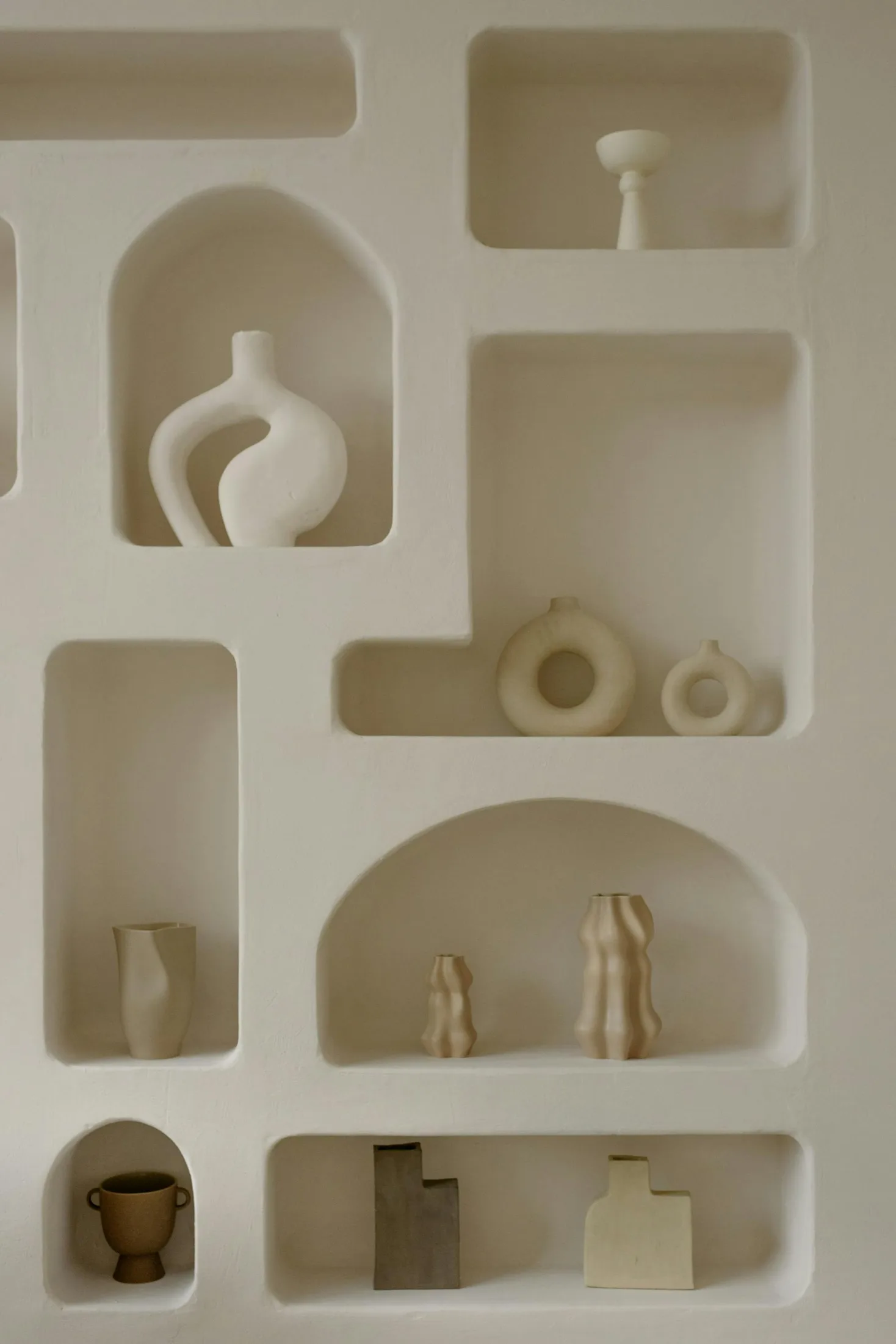 Warm neutral wall shelf with sculptural ceramic objects