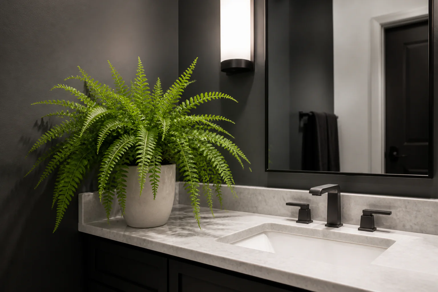 Realistic faux fern in an off-white planter on a black and white bathroom vanity