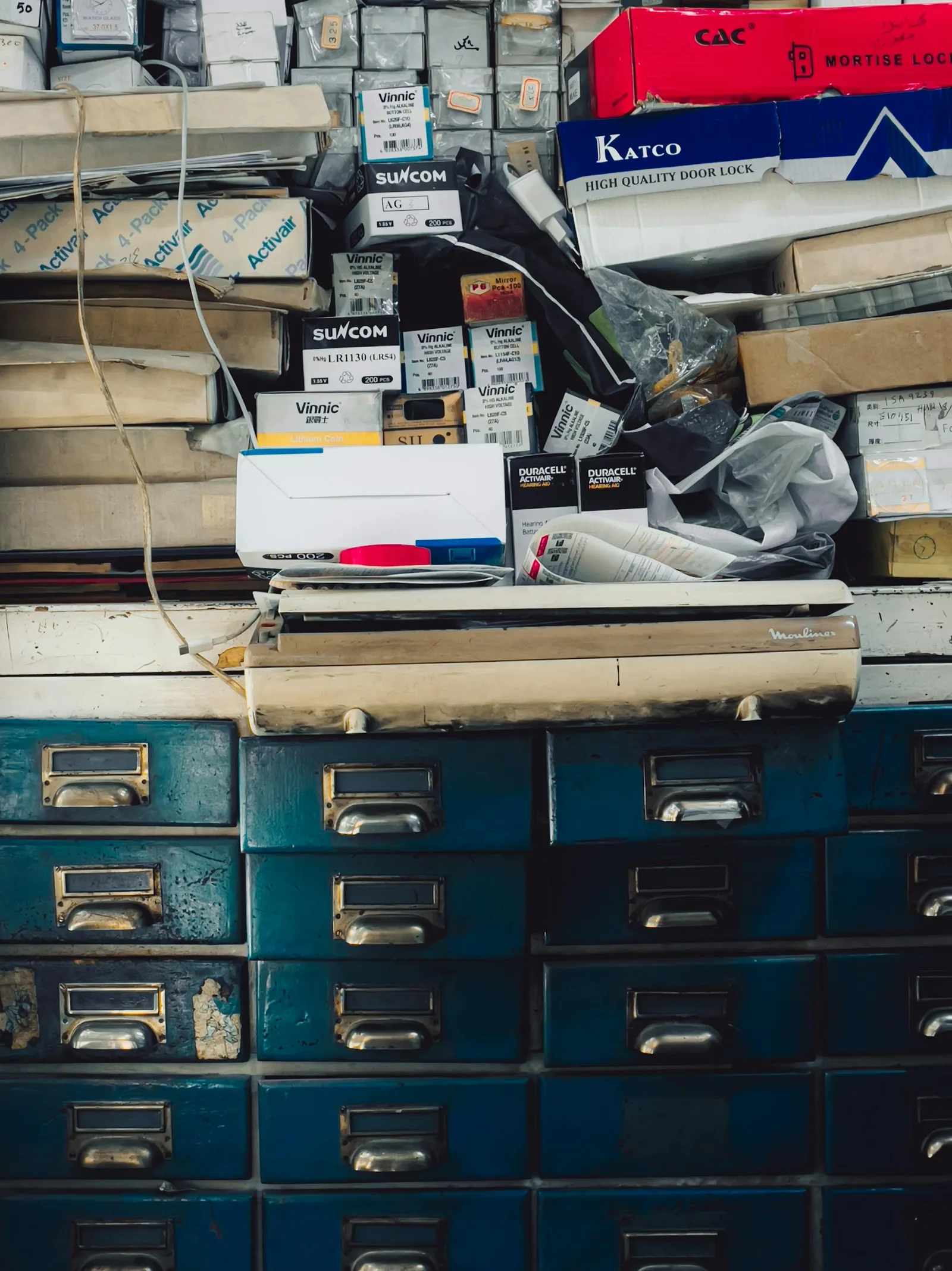 Overstuffed storage cabinet with boxes and unused objects showing visual clutter