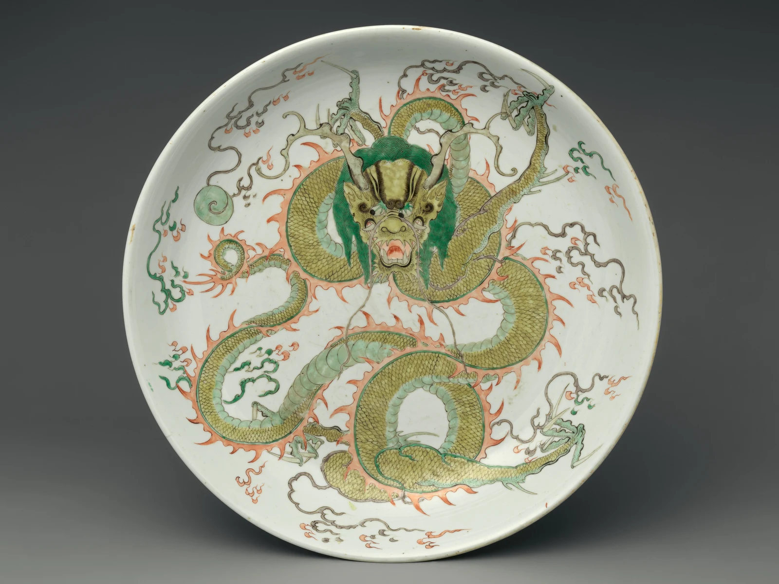 A Chinese porcelain dish showing a dragon surrounded by colorful clouds