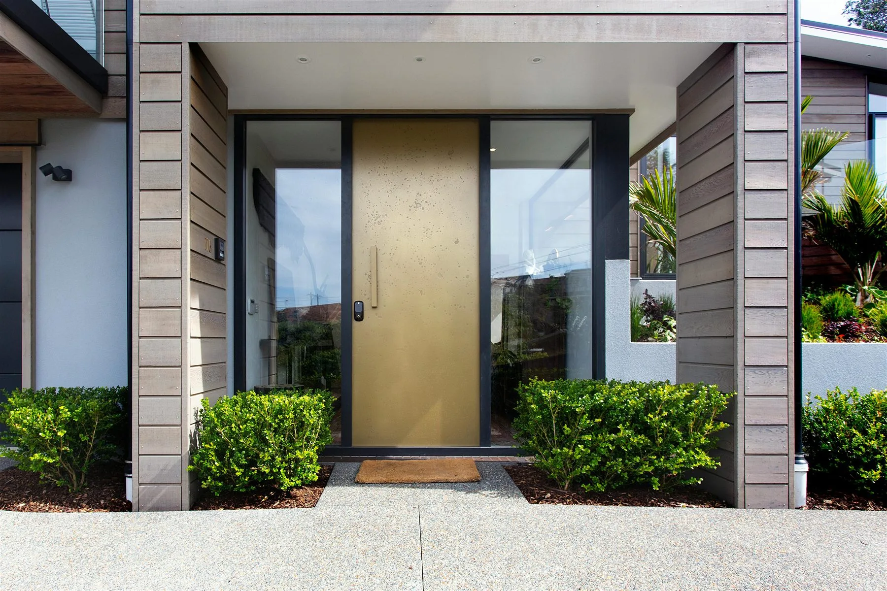 Modern front door with a clear mat, low planting, and an uncluttered path
