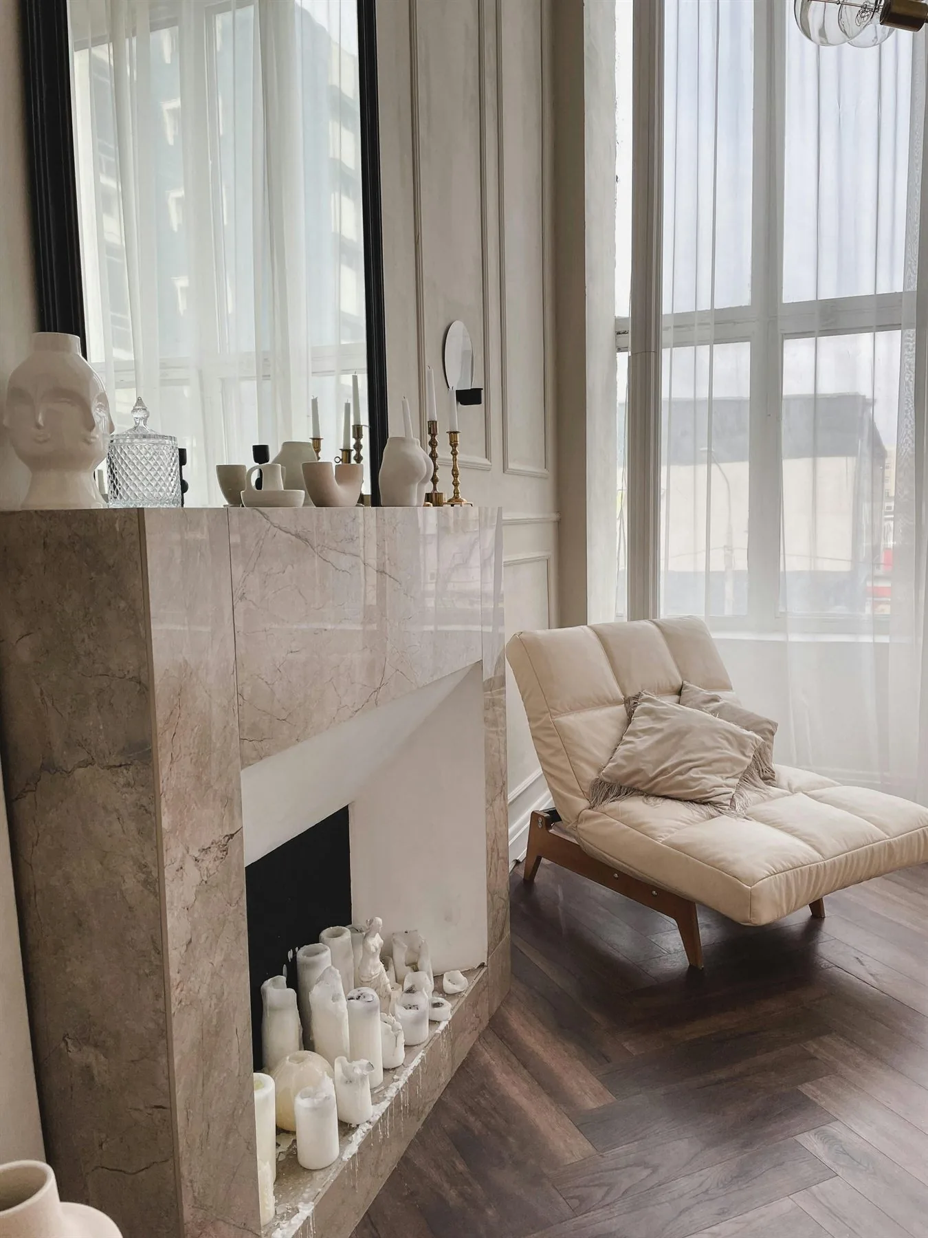 Elegant neutral room with cream chair, fireplace, and warm daylight