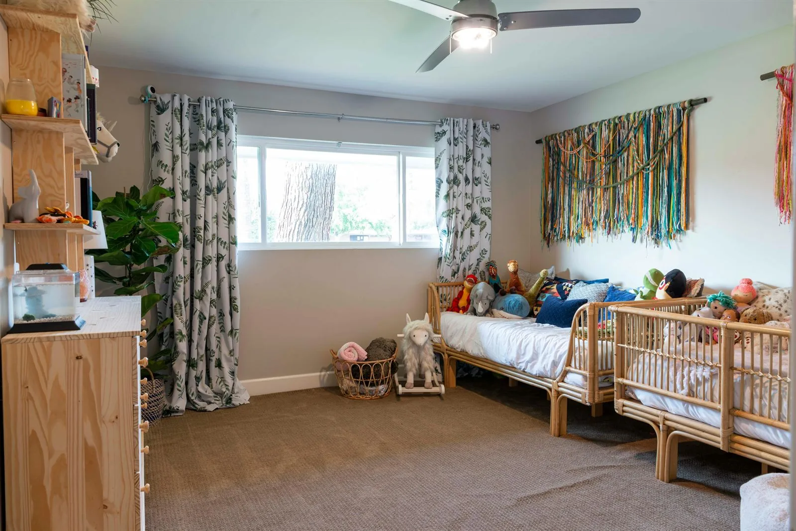 Shared kids room with two rattan beds, stuffed animals, and a calmer neutral palette