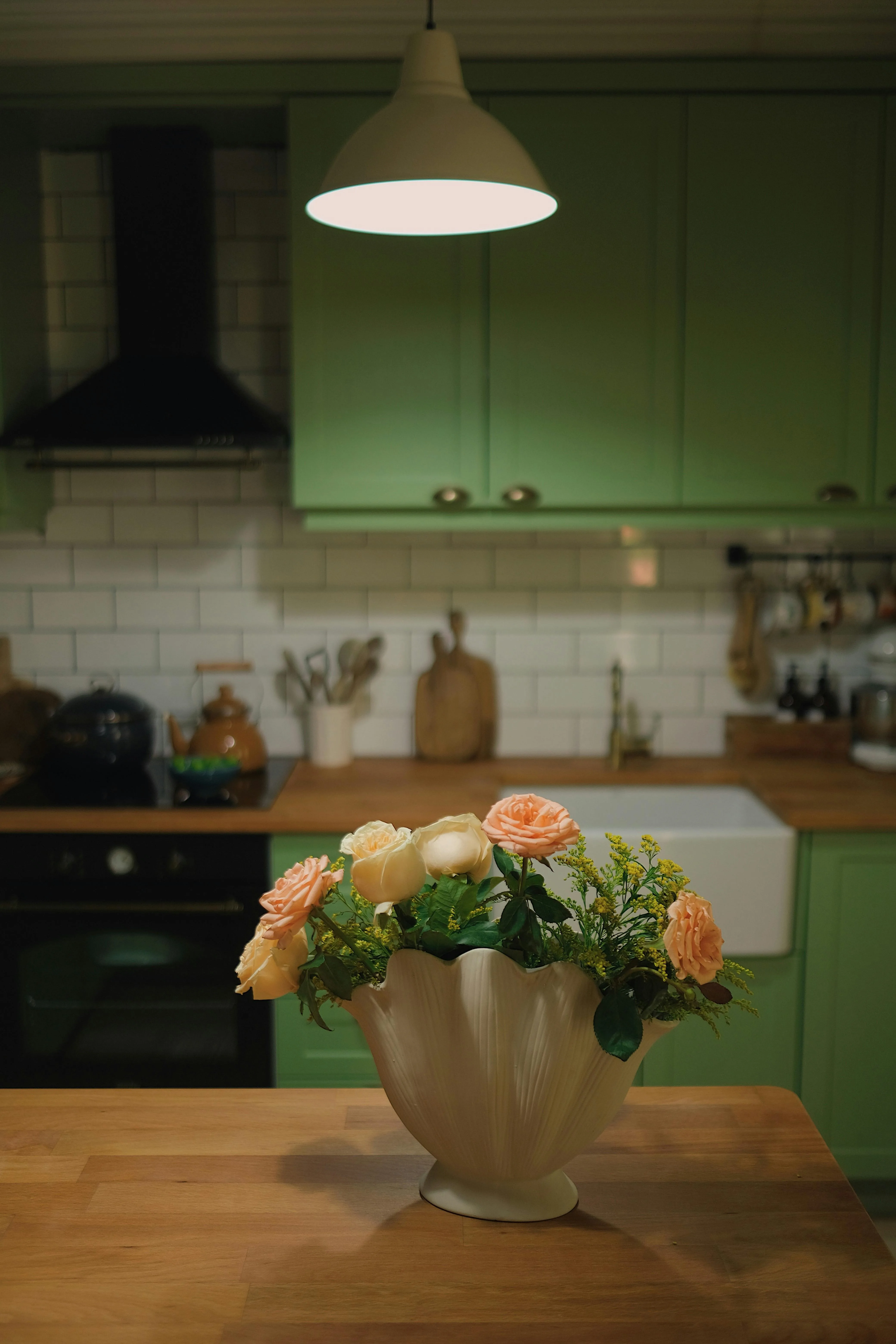 Kitchen counter with a flower vase, warm wood accents, and softly edited styling