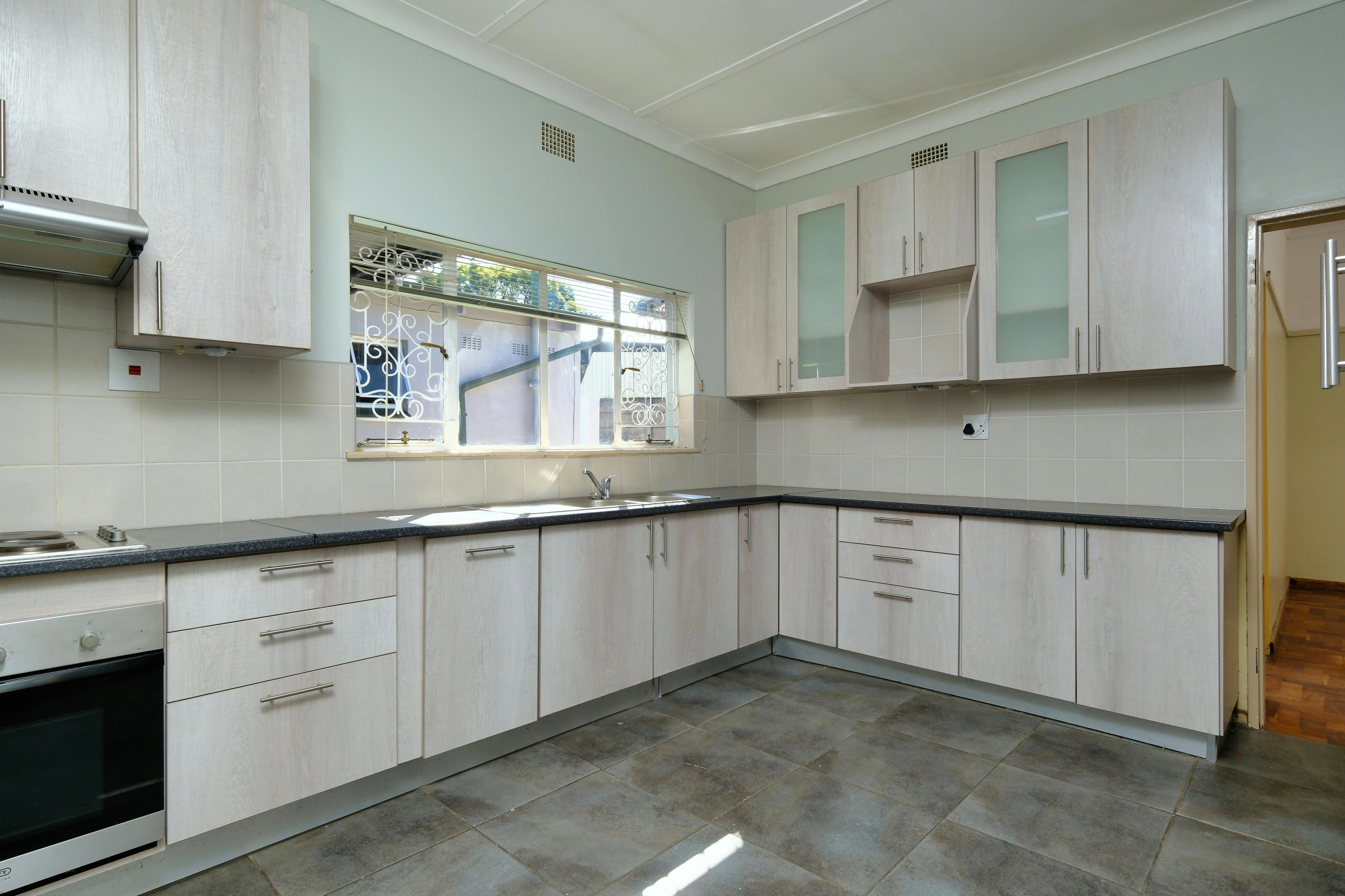 Bright modern kitchen with natural light, pale cabinets, and a clean central work zone