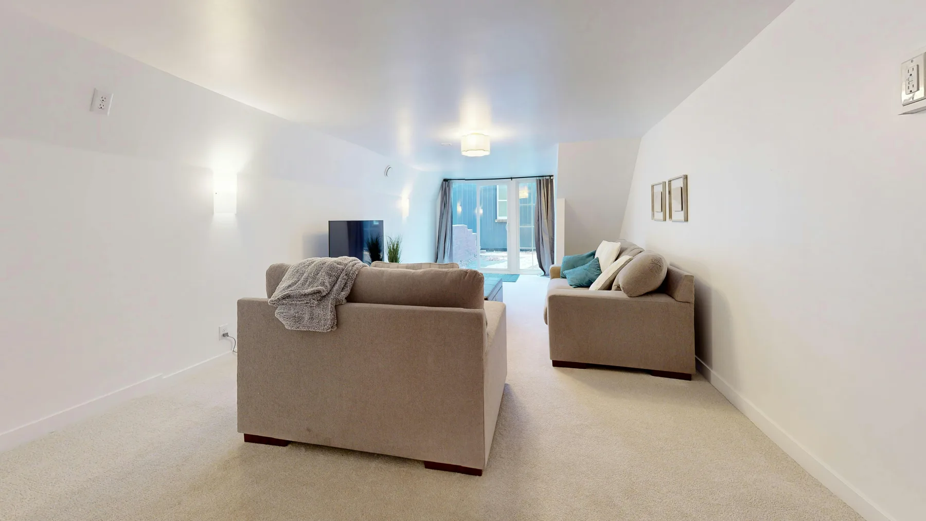Narrow living room with a calm sofa arrangement, warm wood, and a readable path through the space