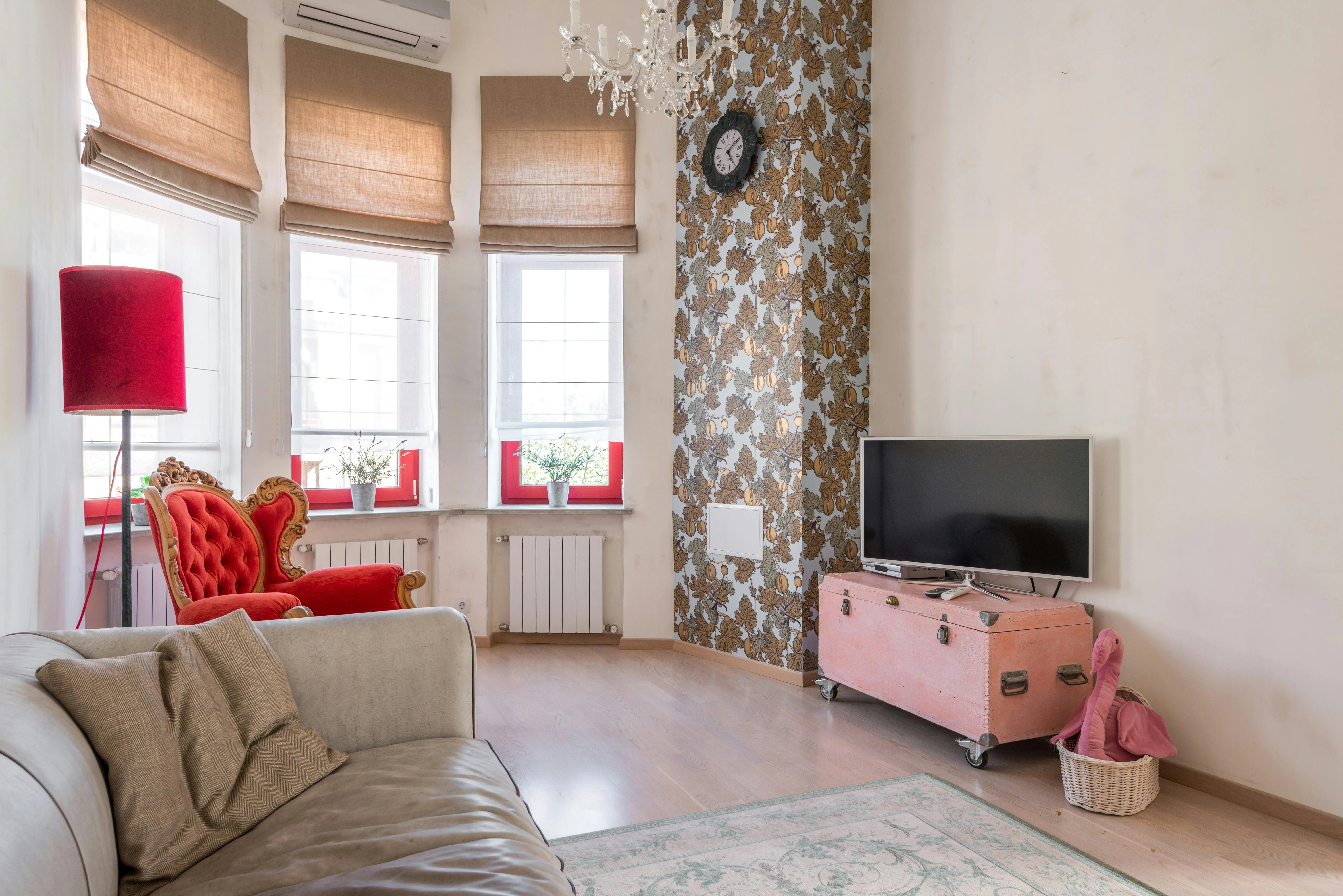 Living room with patterned wall, bright accent chair, television, and several strong statements in one space