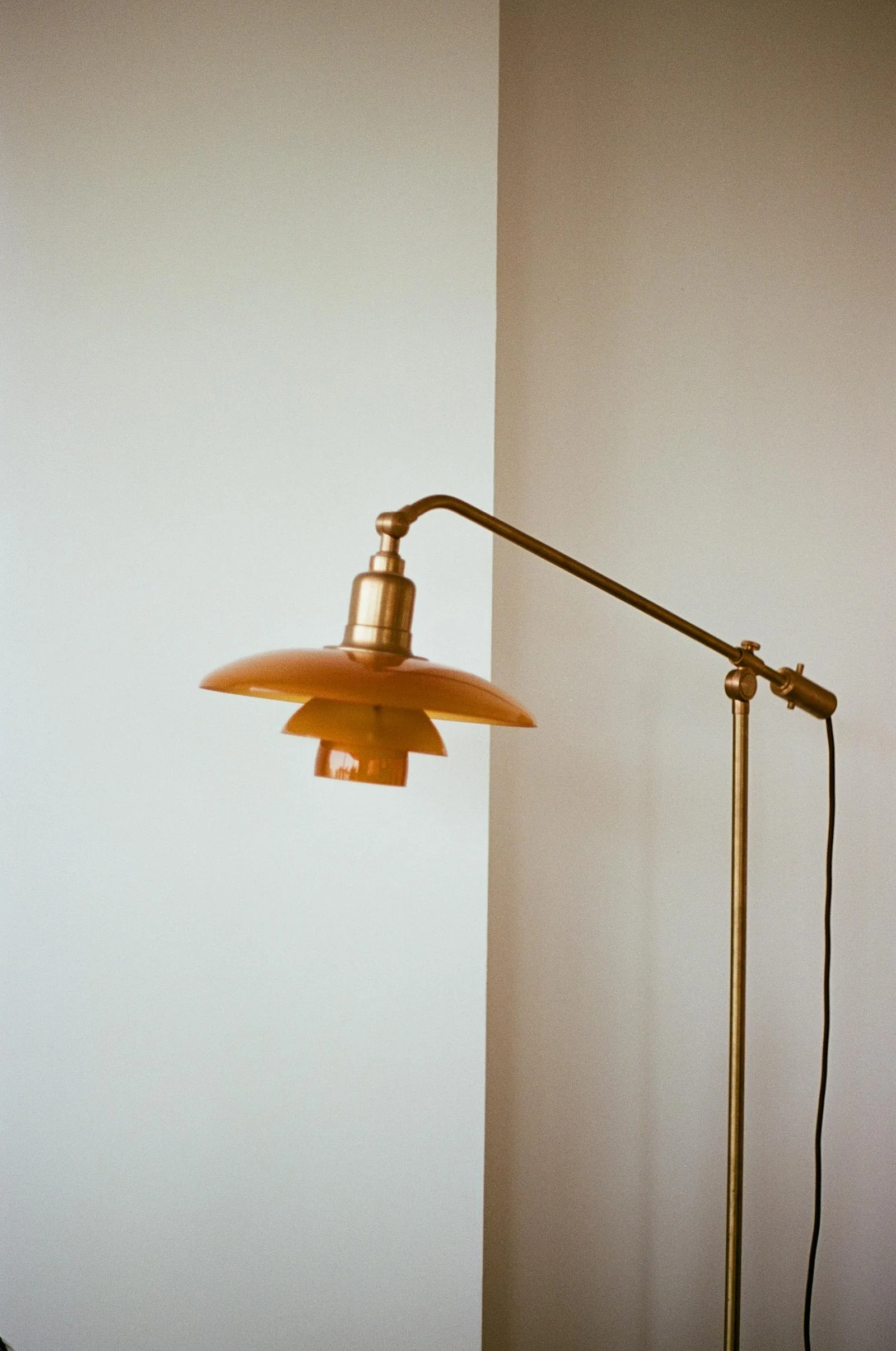 Brass floor lamp against soft warm white walls