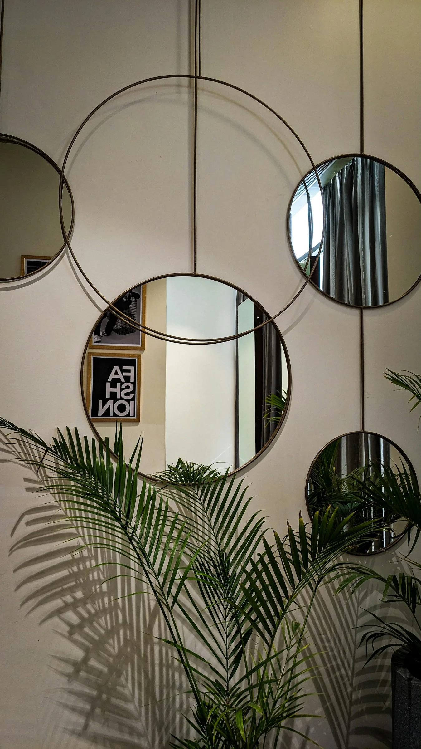Circular mirror in a living room with plants and soft natural decor