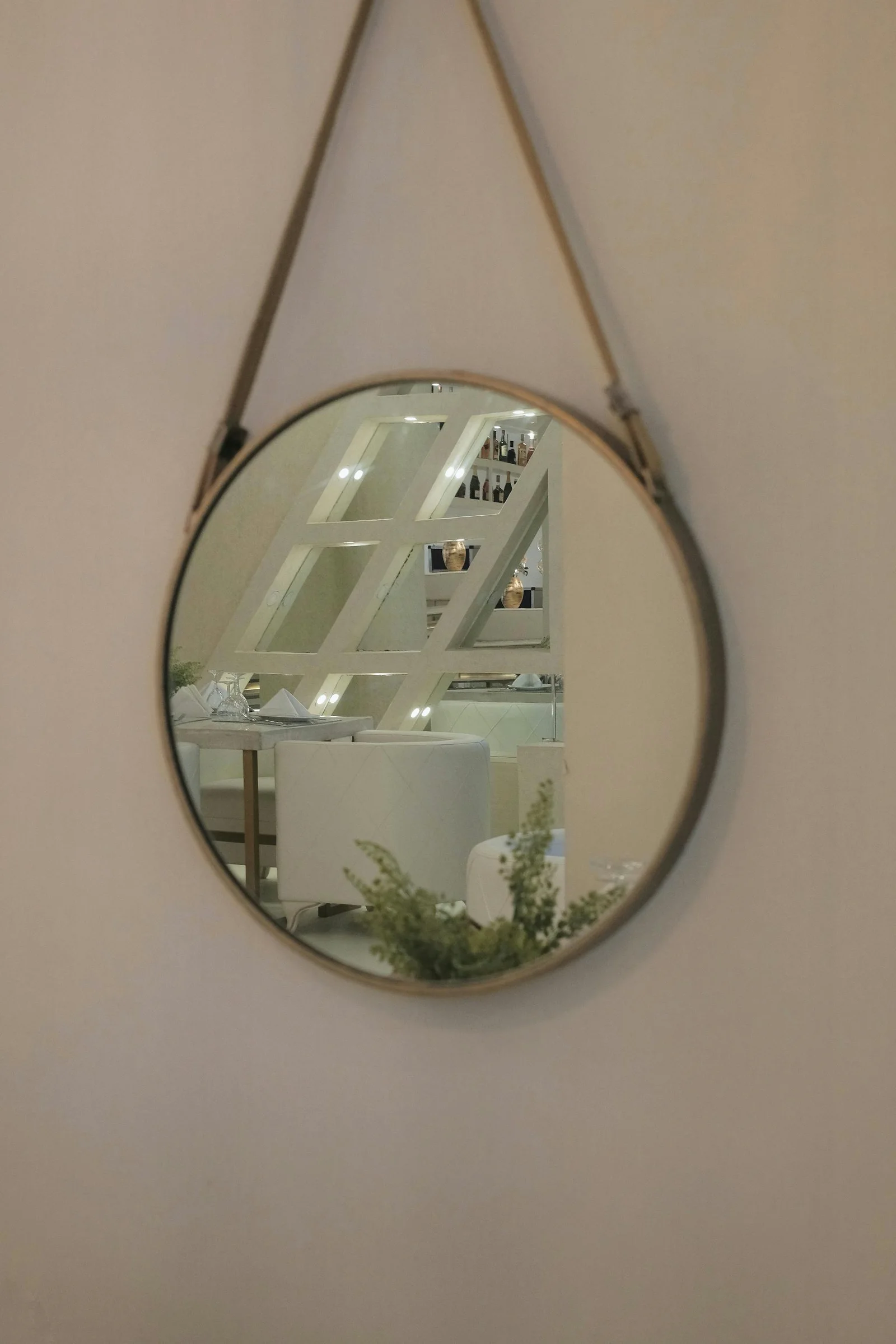 Round wall mirror reflecting a calm bright room
