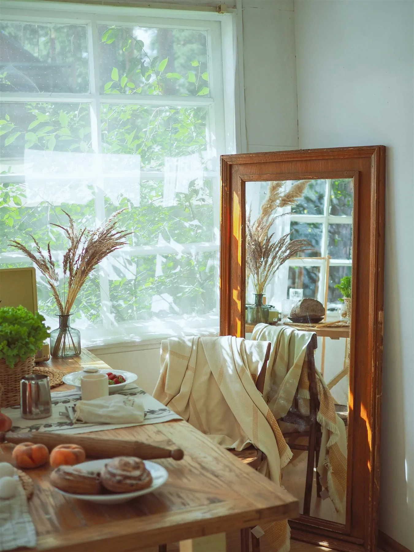 Dining room mirror reflecting a sunlit table and soft neutral textiles