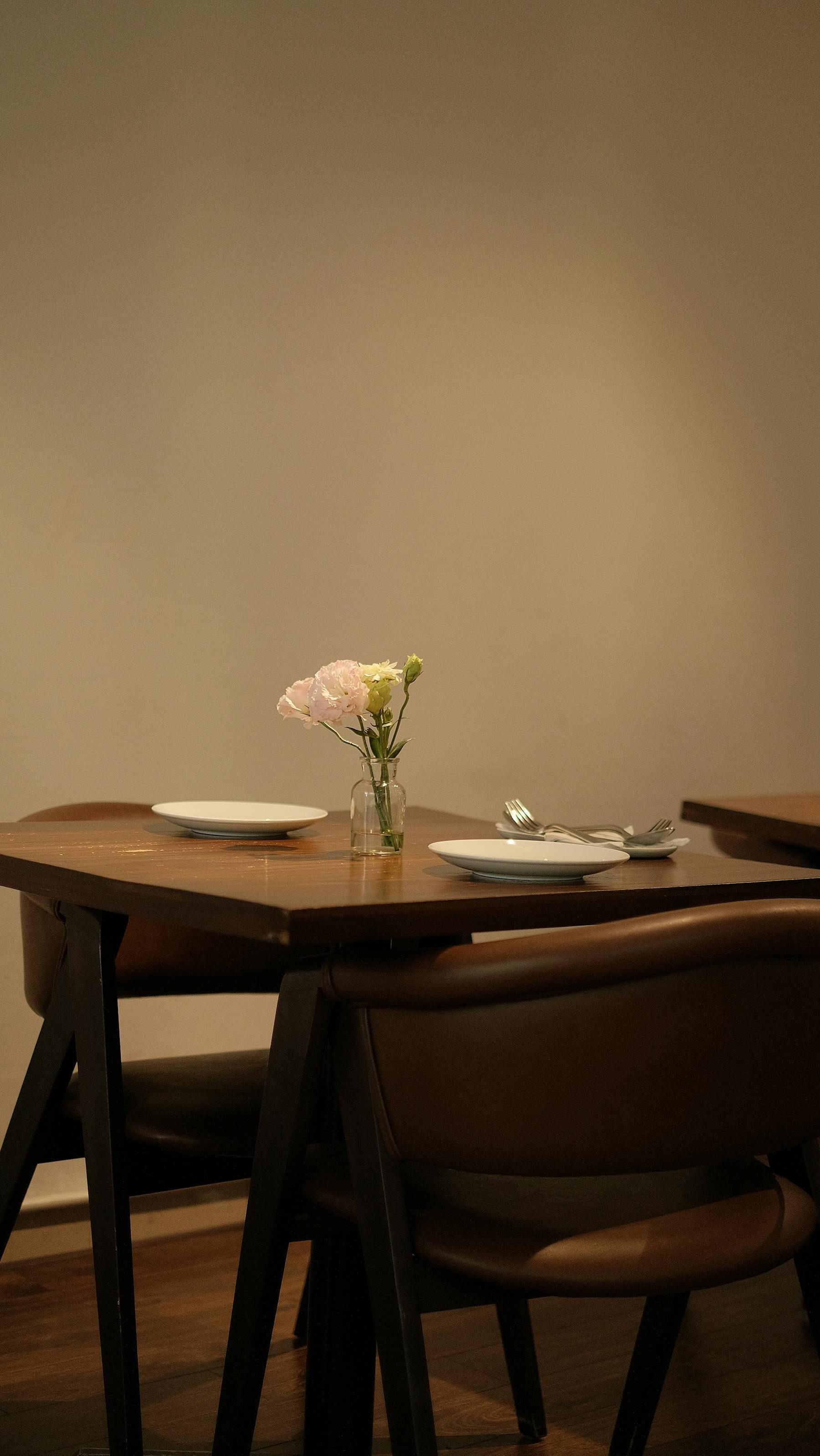 Simple dining table with flowers and place settings in a quiet warm room