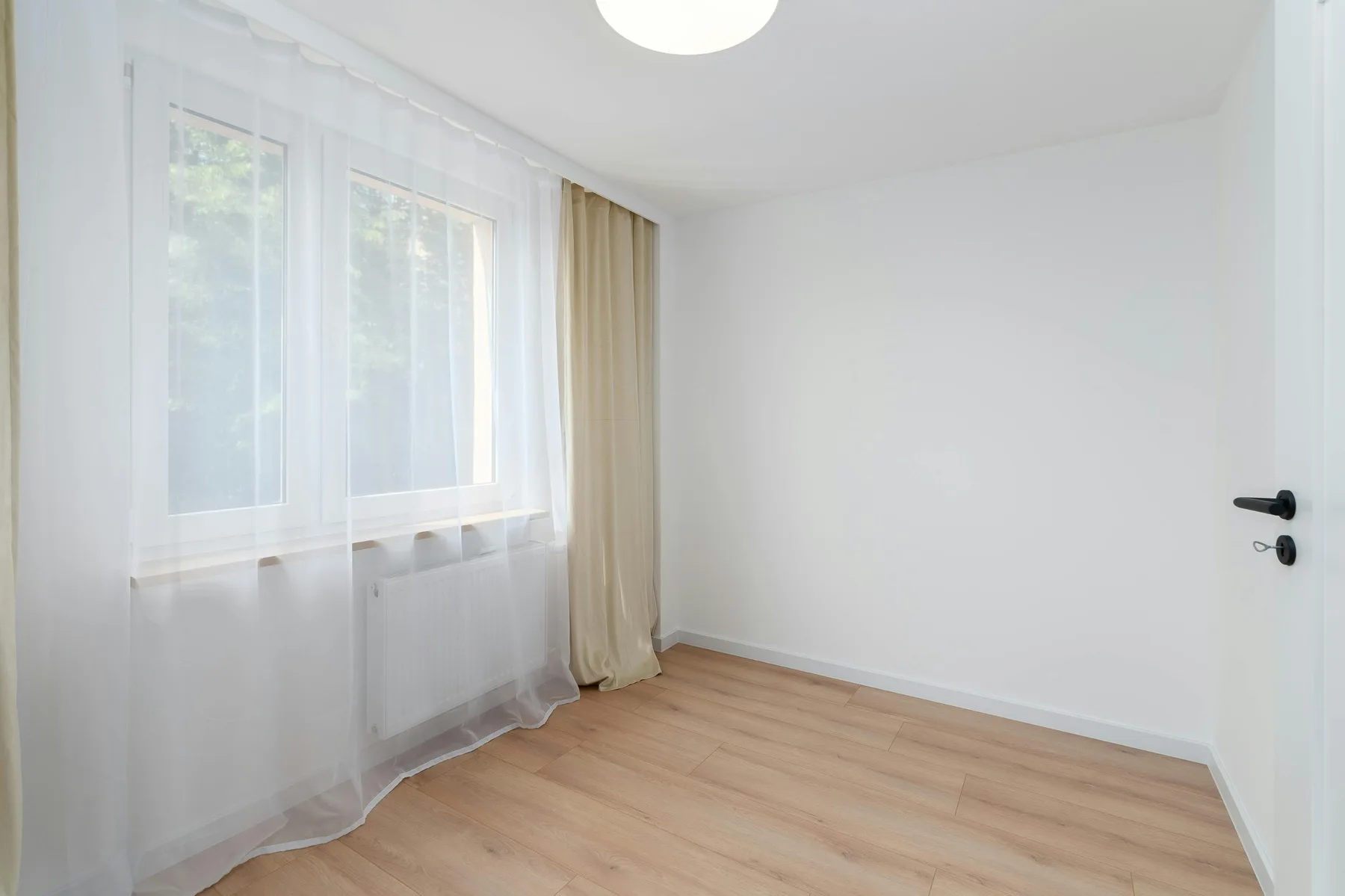 Calm empty room with clean floors, balanced daylight, and space to settle before decorating