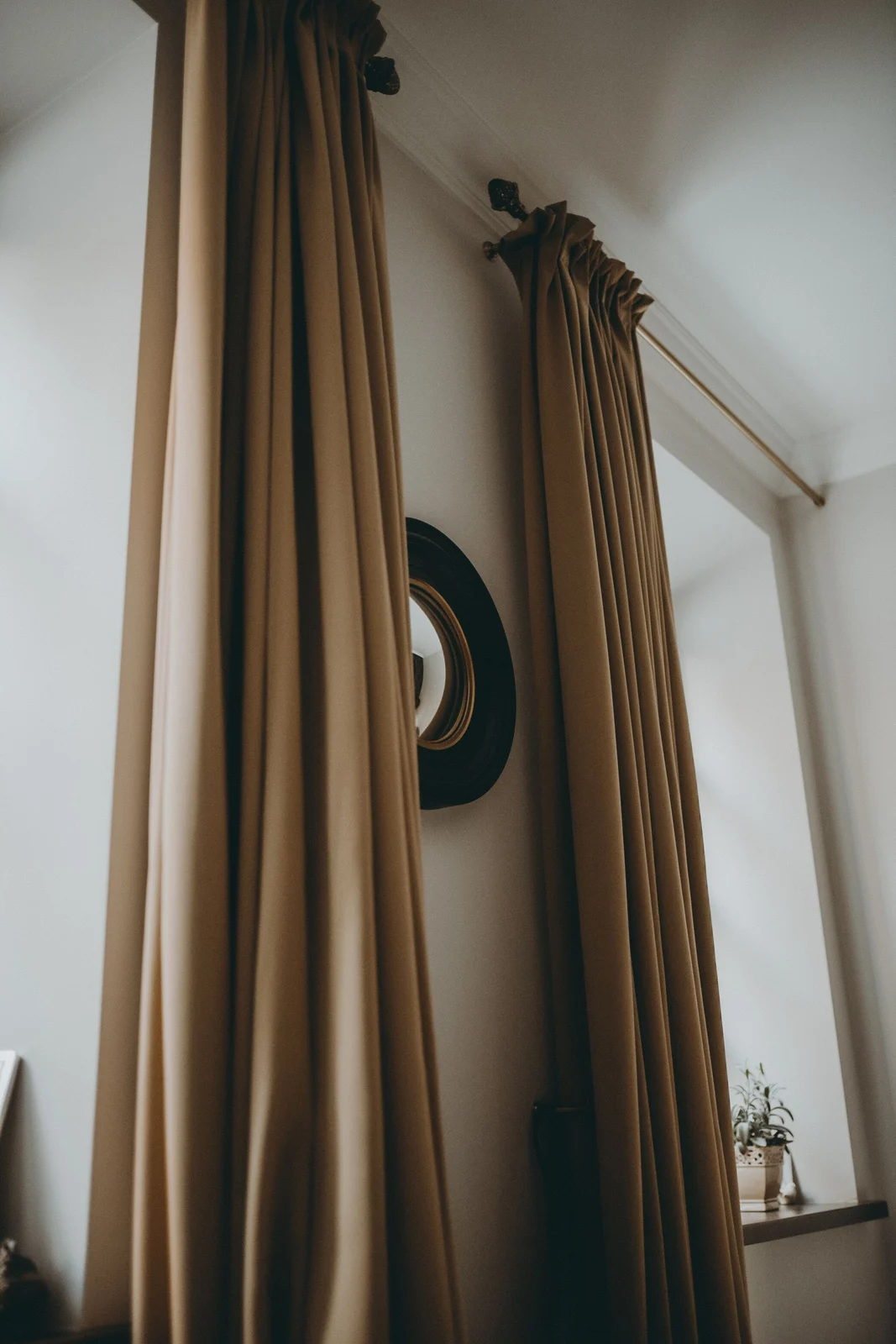 Close view of gathered brown curtain headers on a wall-mounted rod