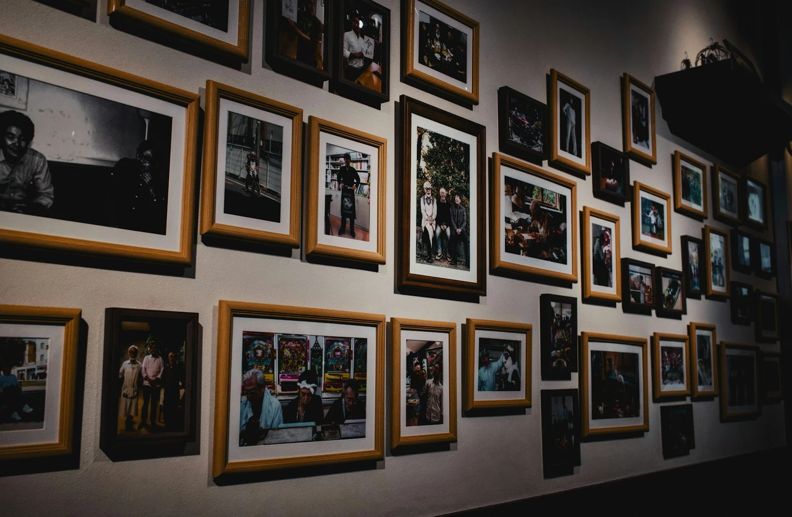 A wall display of framed photographs in assorted frame sizes