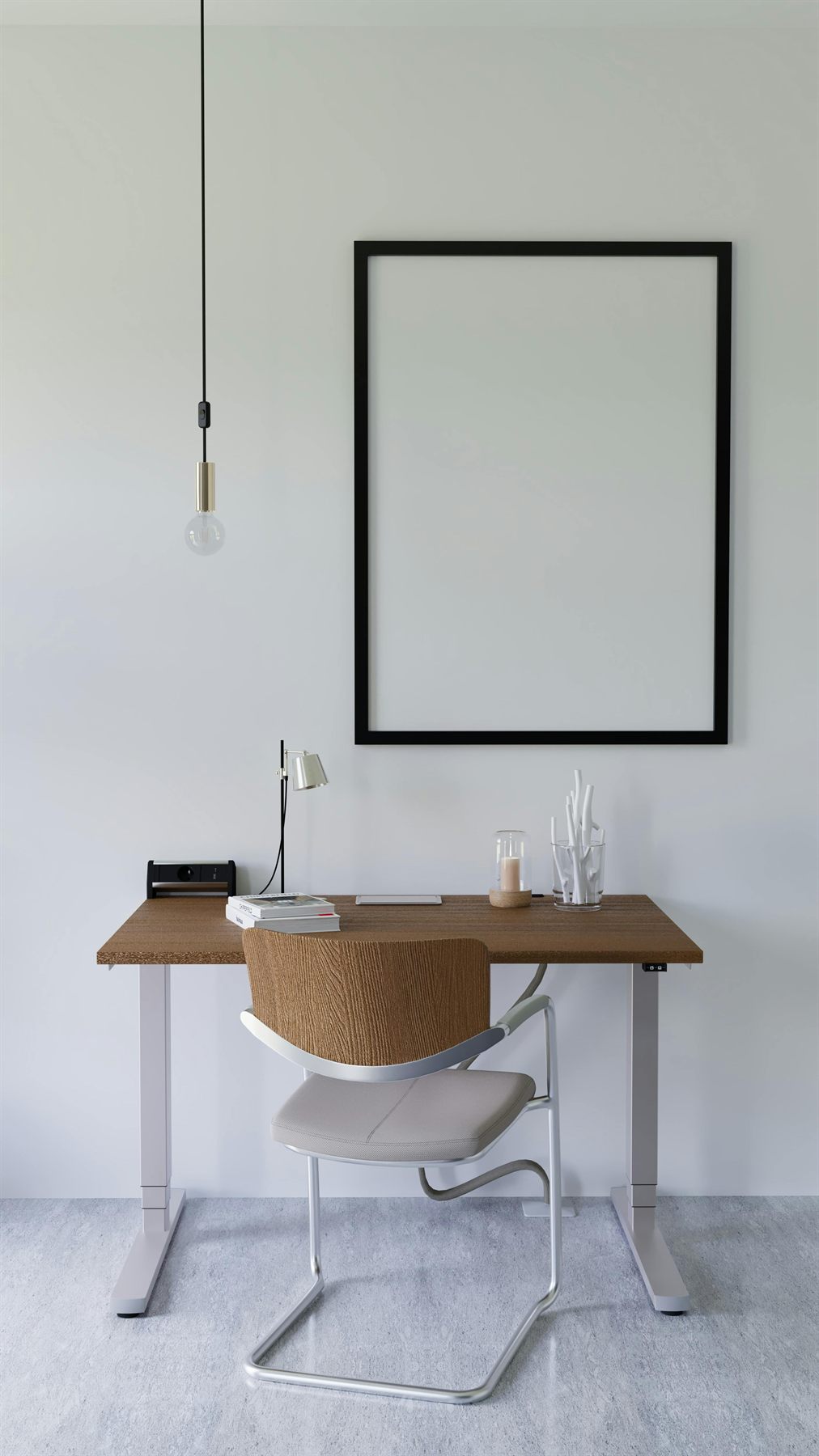 Wood desk and white chair in a simple office with a large blank frame and a pale wall