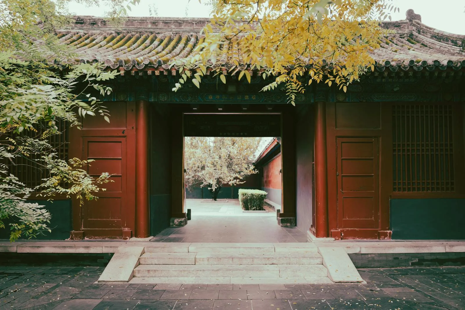 Traditional courtyard building with trees, tiled roof, and a centered opening