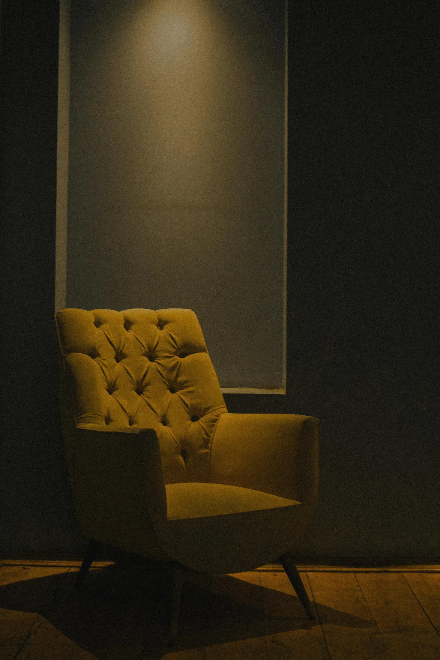 Amber accent chair against a dark wall showing a warm fire element color used in a small dose
