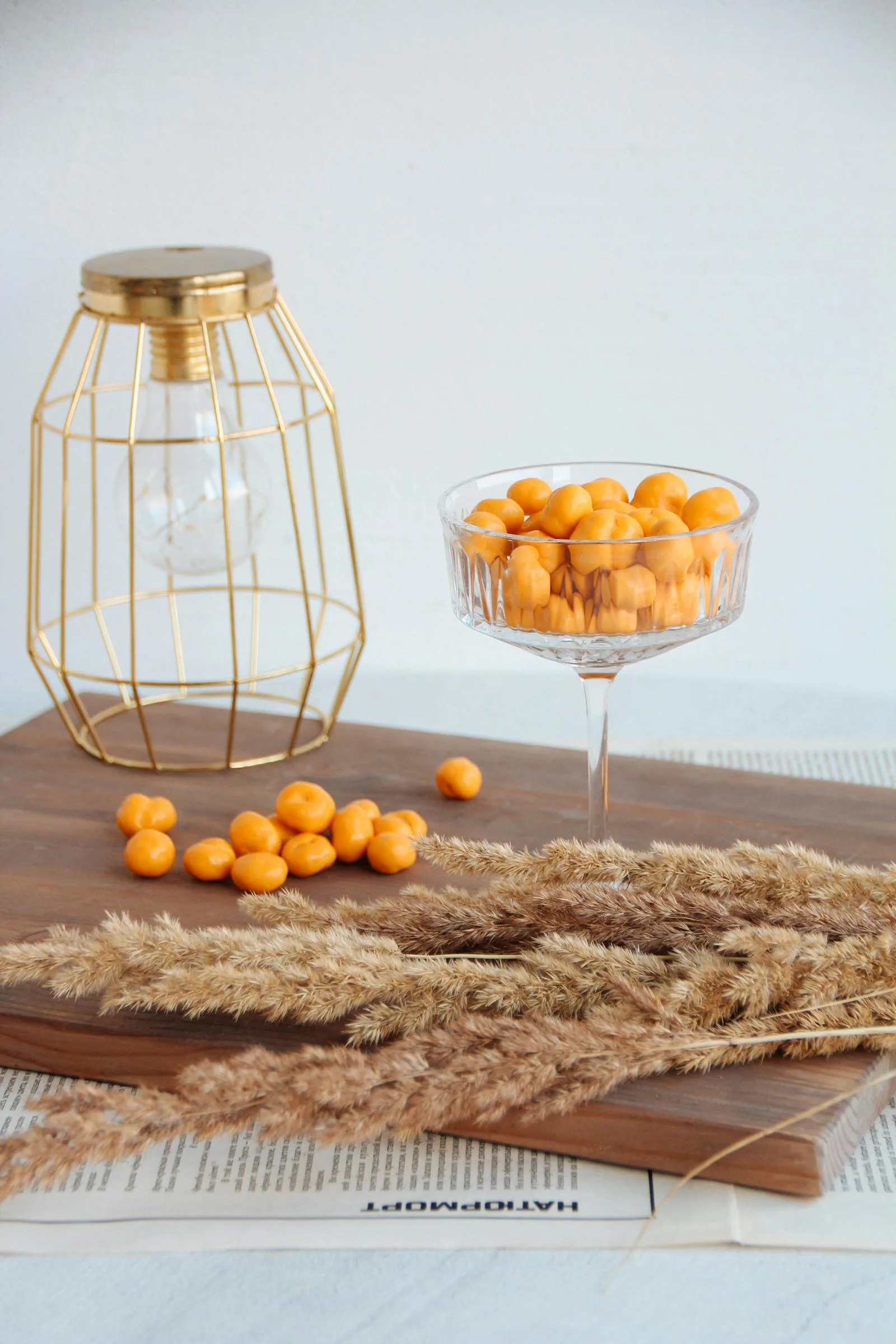 Warm lamp beside a glass bowl of bright fruit on a styled tabletop