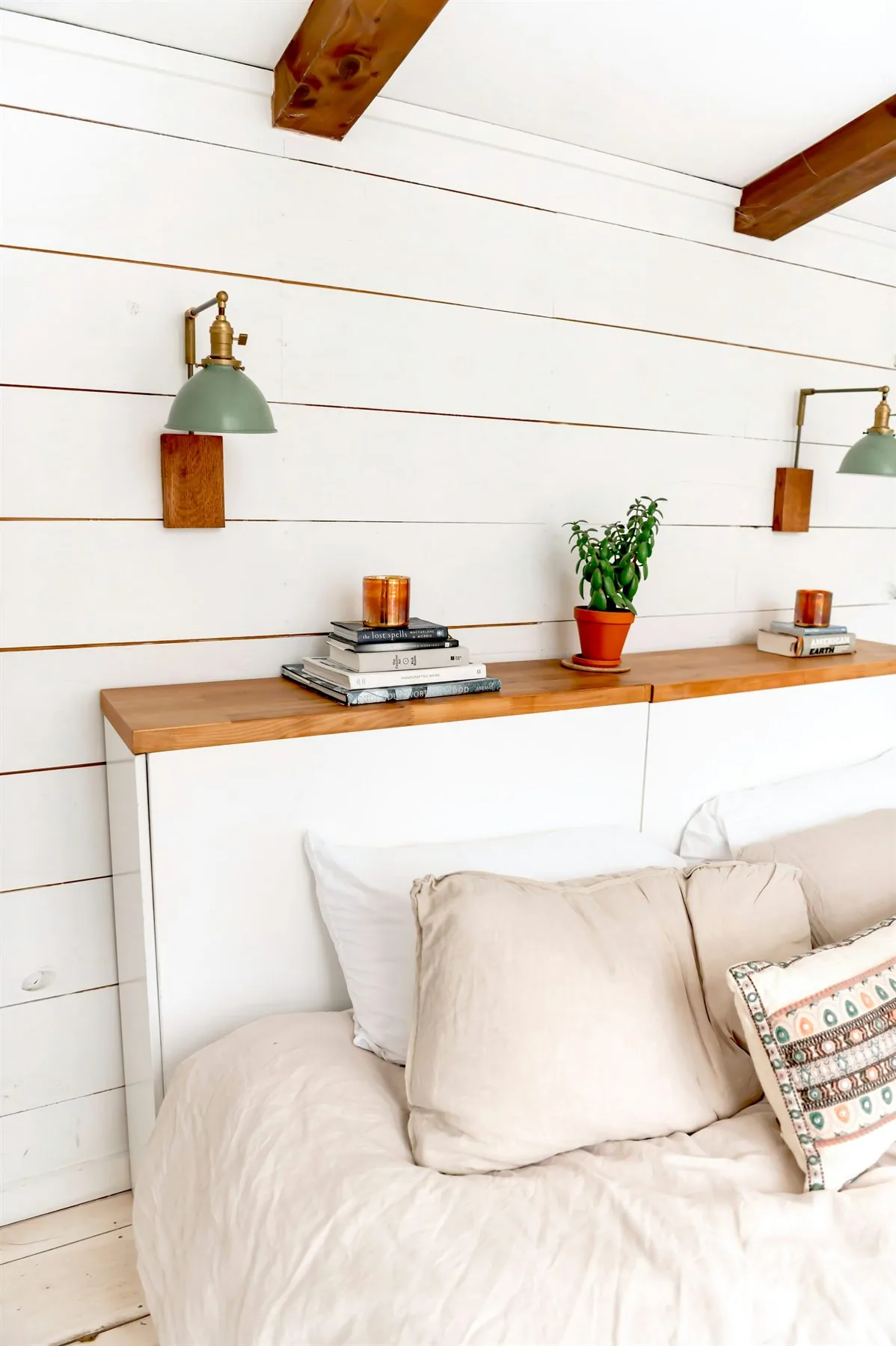 Warm ivory bedroom with soft bedding, wood sconces, and a calm romantic palette