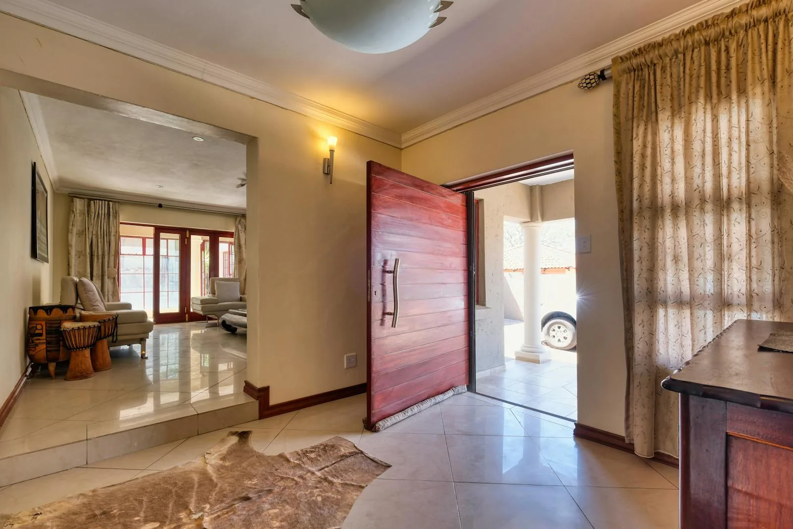 Bright entry with an open wood front door and strong natural light across the floor