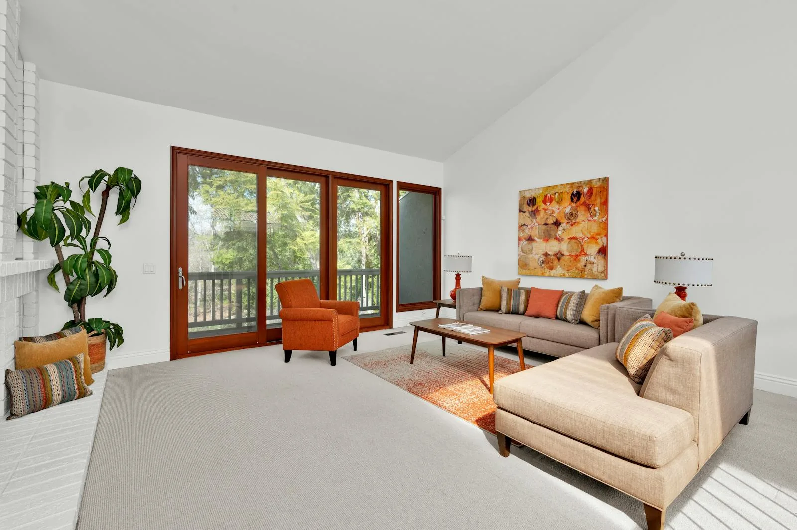 Bright living room with large windows, warm wood trim, and a grounded seating arrangement
