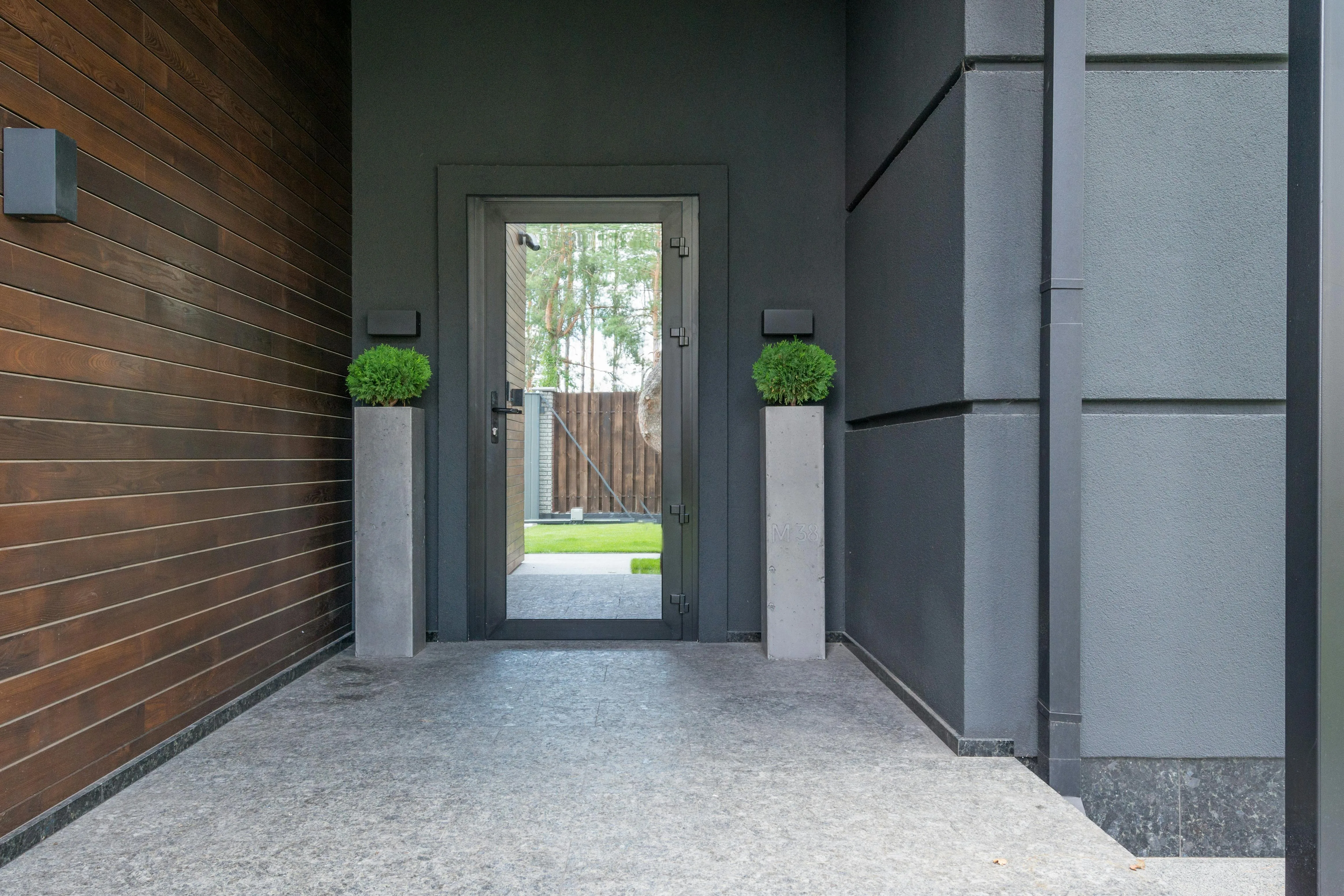 Modern home entrance with shade, greenery, and a defined front path