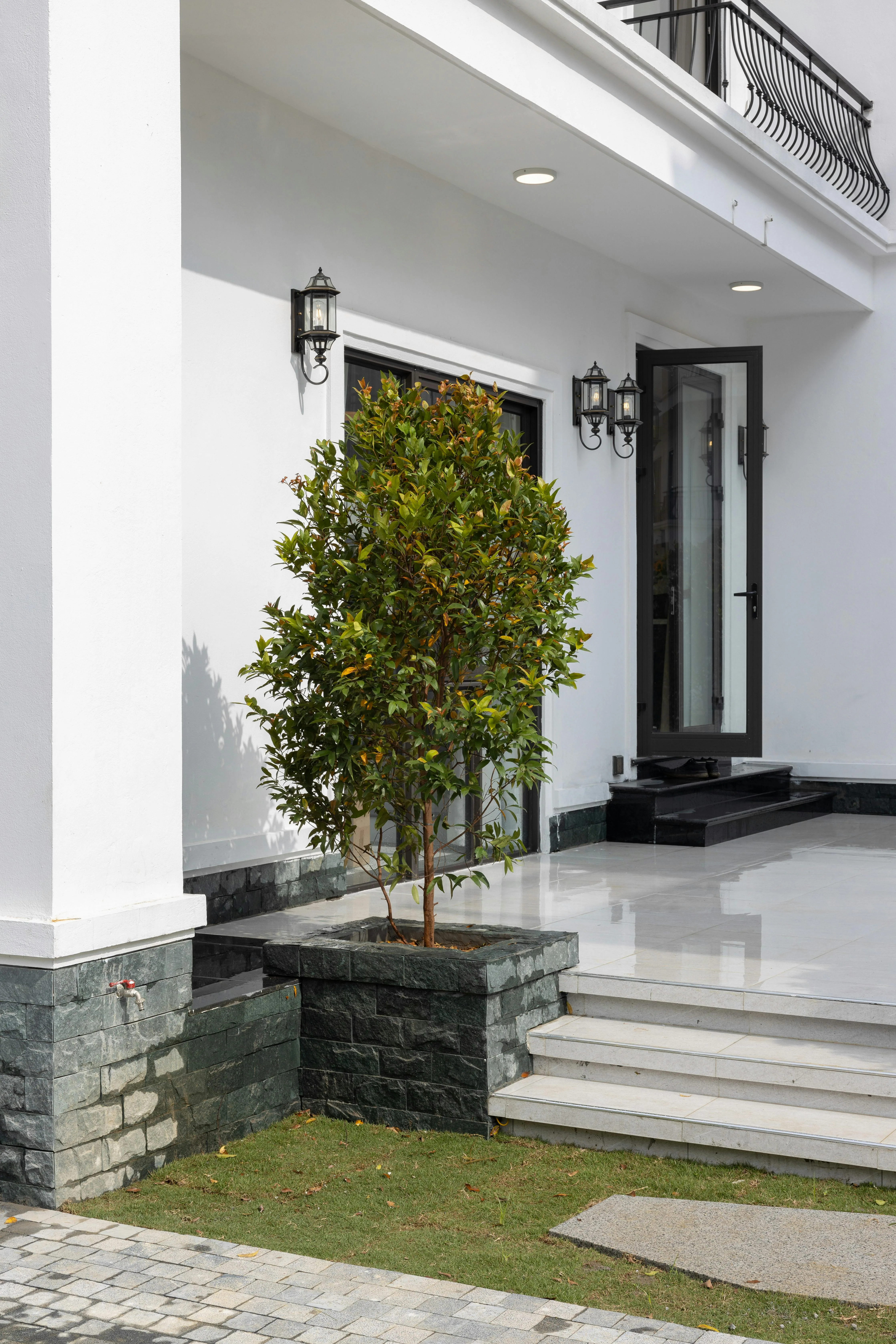 Tall front entry with greenery, steps, and a more sheltered arrival sequence