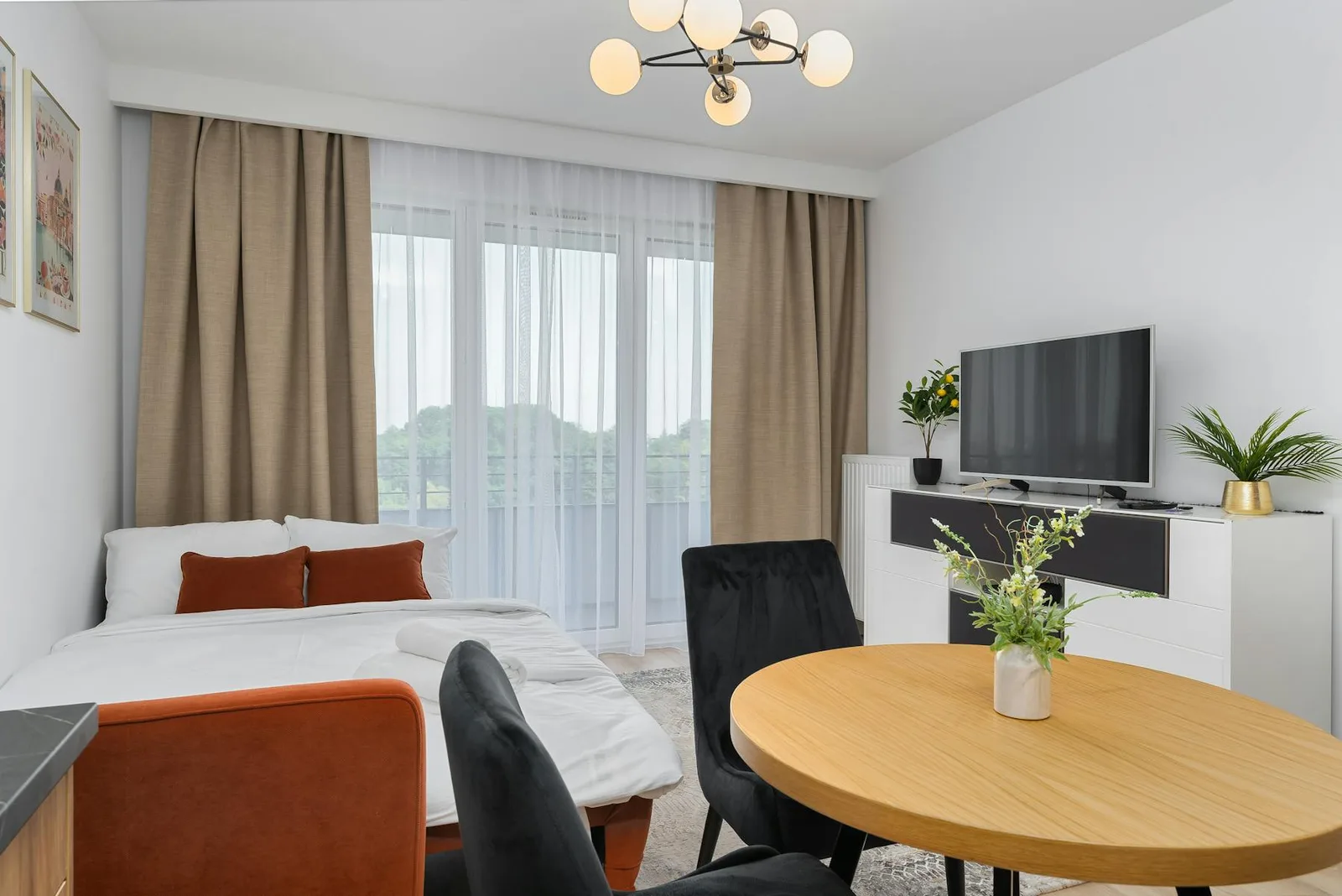 Compact studio apartment with bed, dining table, TV wall, and clearer zones