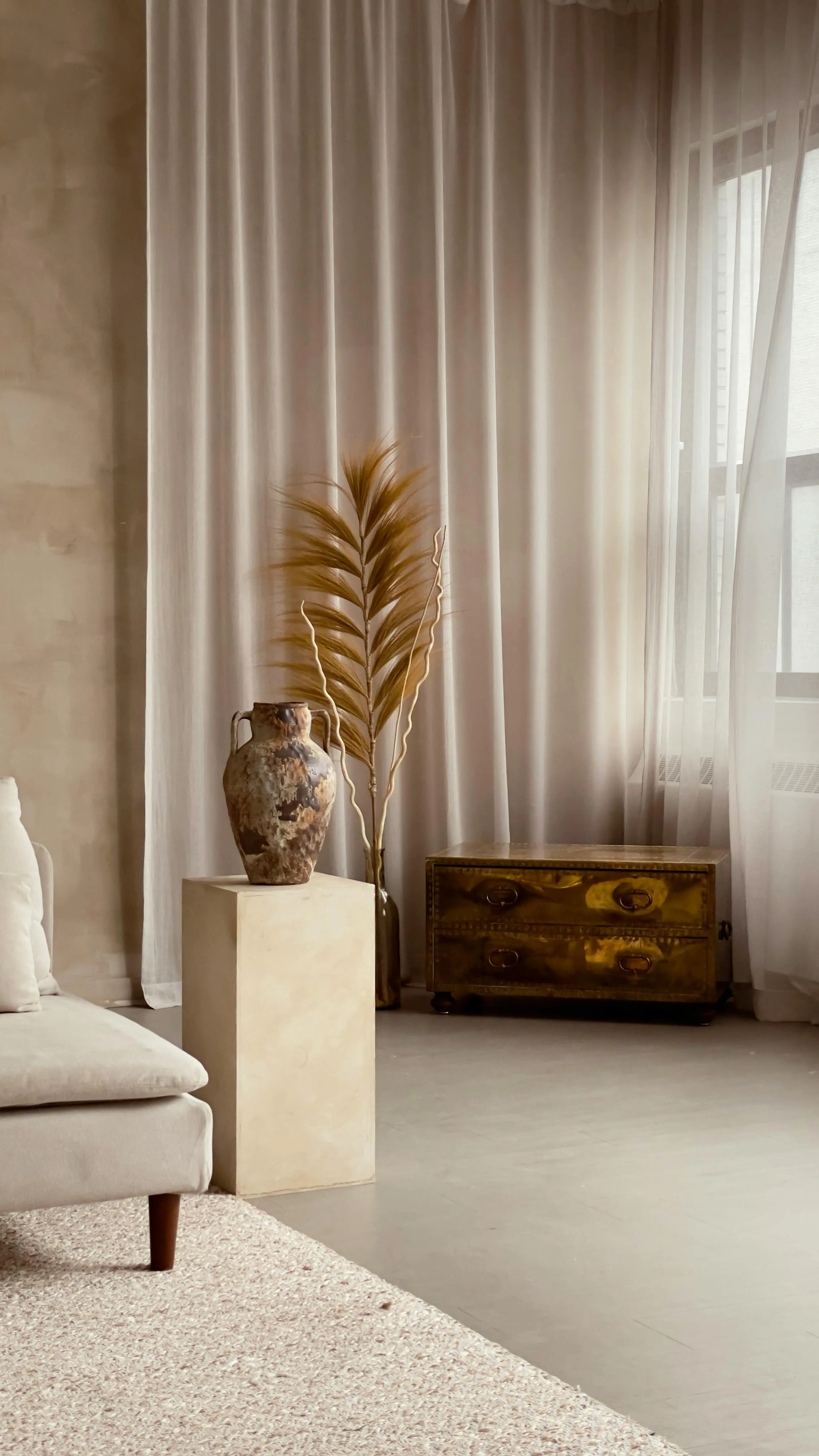 Quiet neutral interior with handmade ceramics, layered texture, and restrained styling