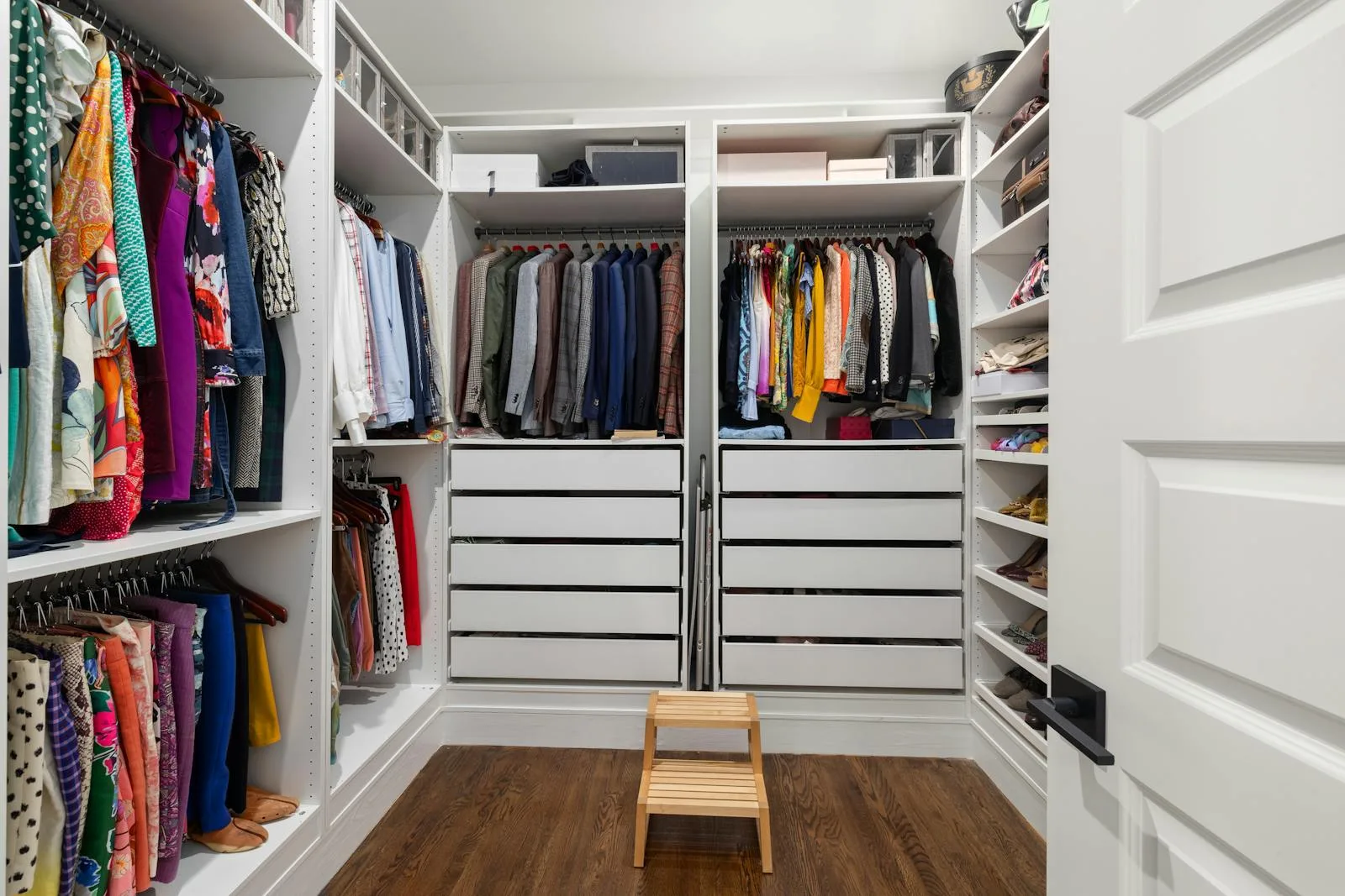 Organized walk-in wardrobe with bright shelving and clear floor space