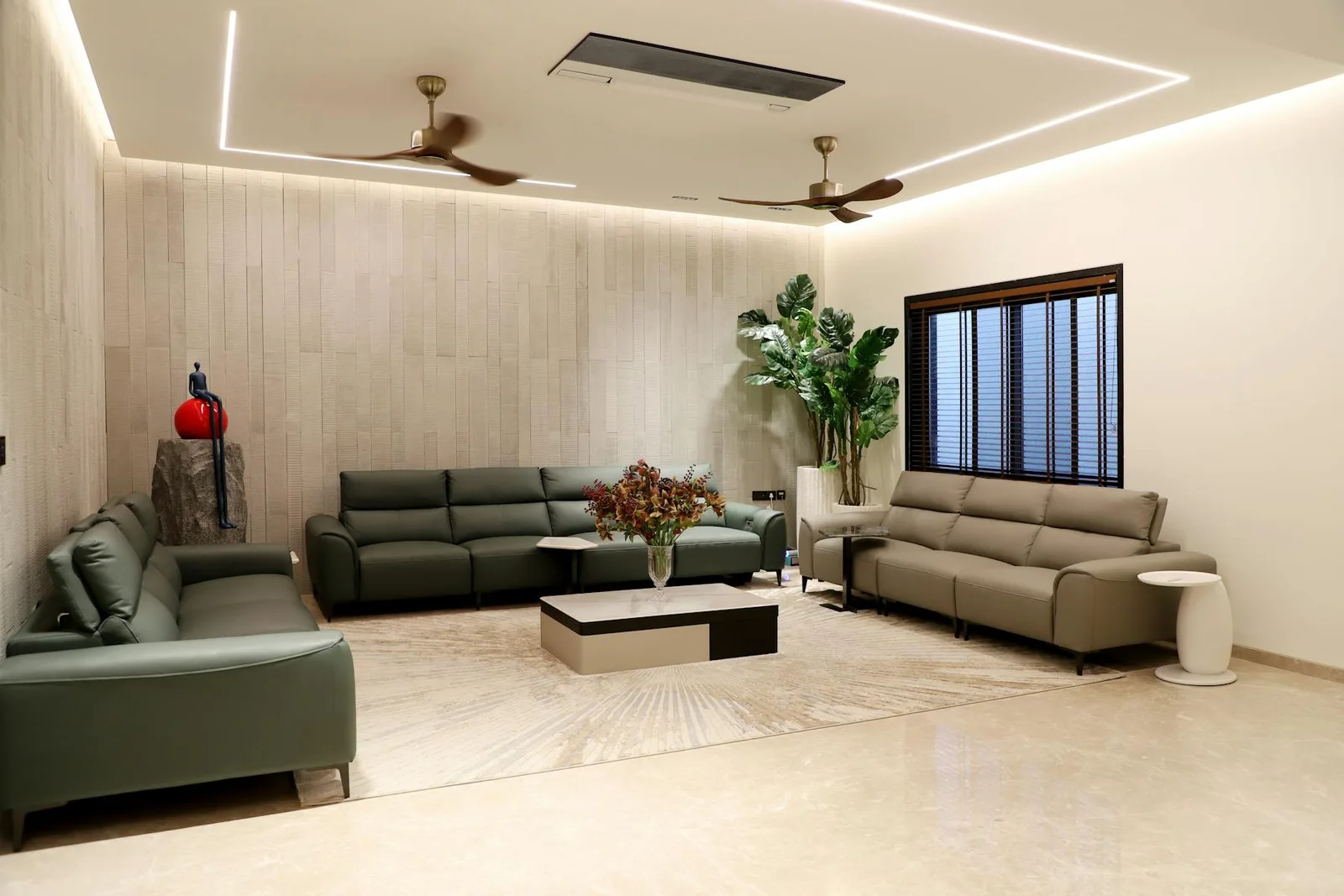 Green seating area with plants, warm flooring, and light neutral walls