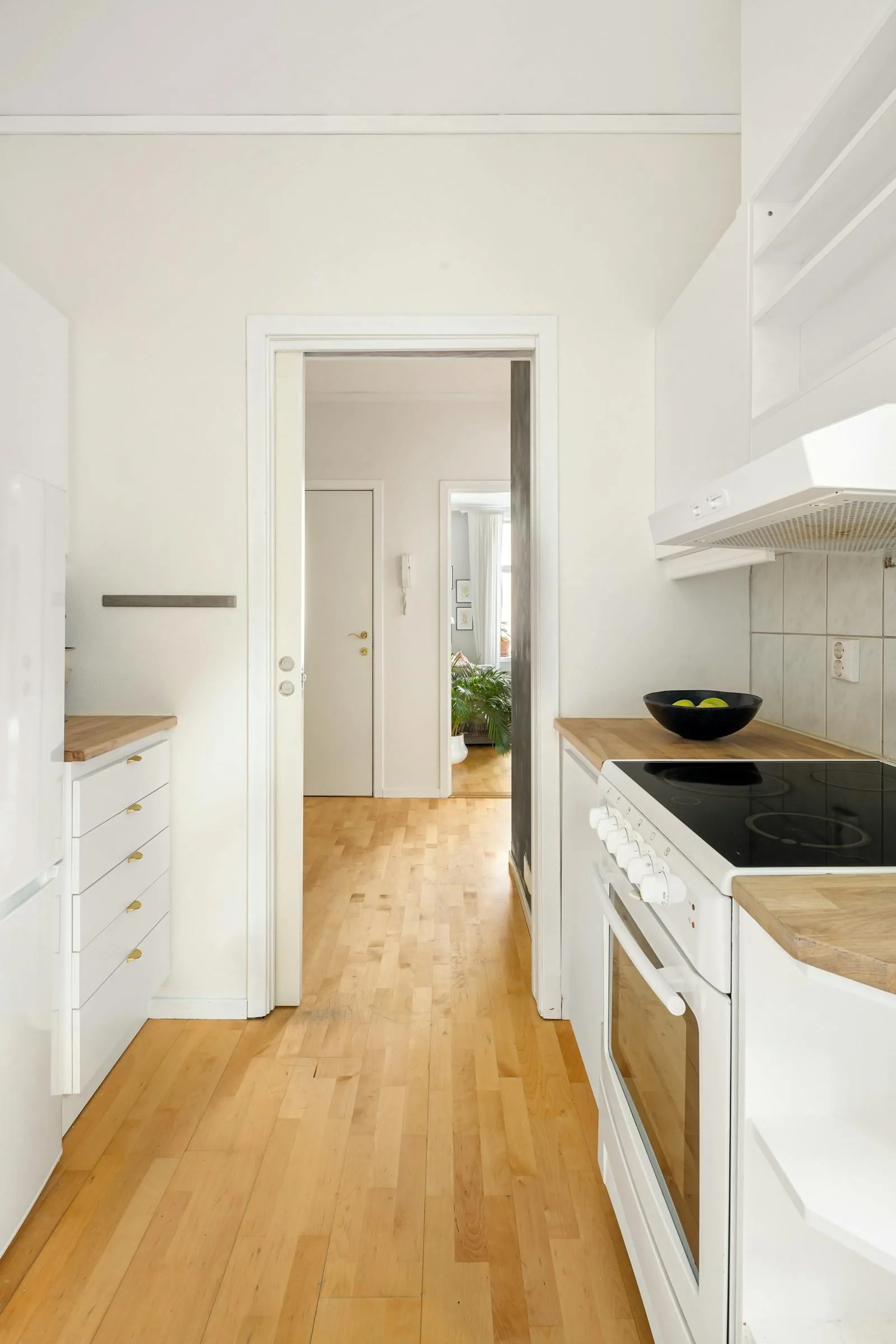 Bright organized kitchen with open counters and a calm uncluttered walkway